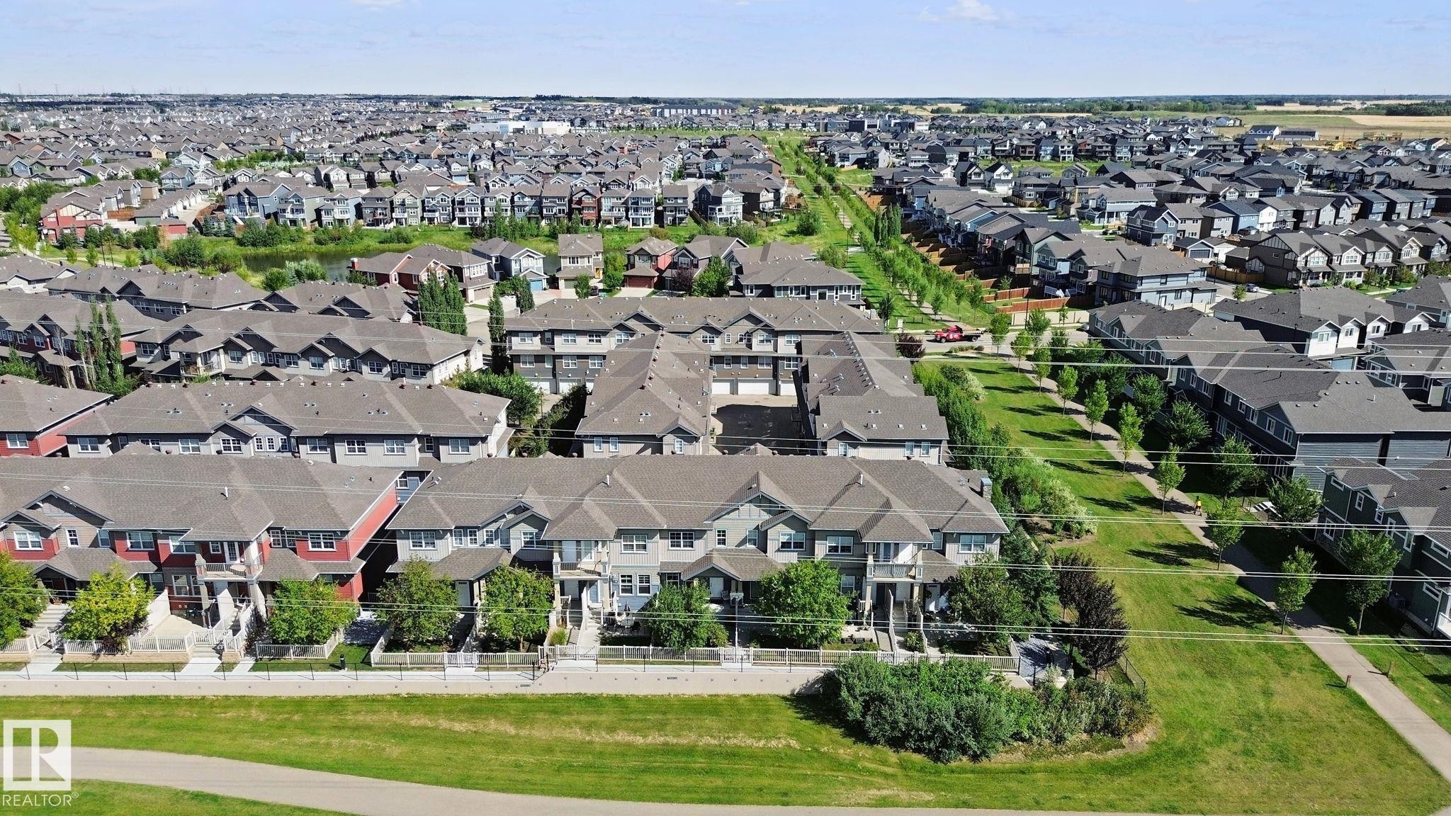 Expansive residential community featuring multiple housing styles, green spaces, and paved pathways - #58 4029 Orchards Dr Sw, Edmonton, AB
