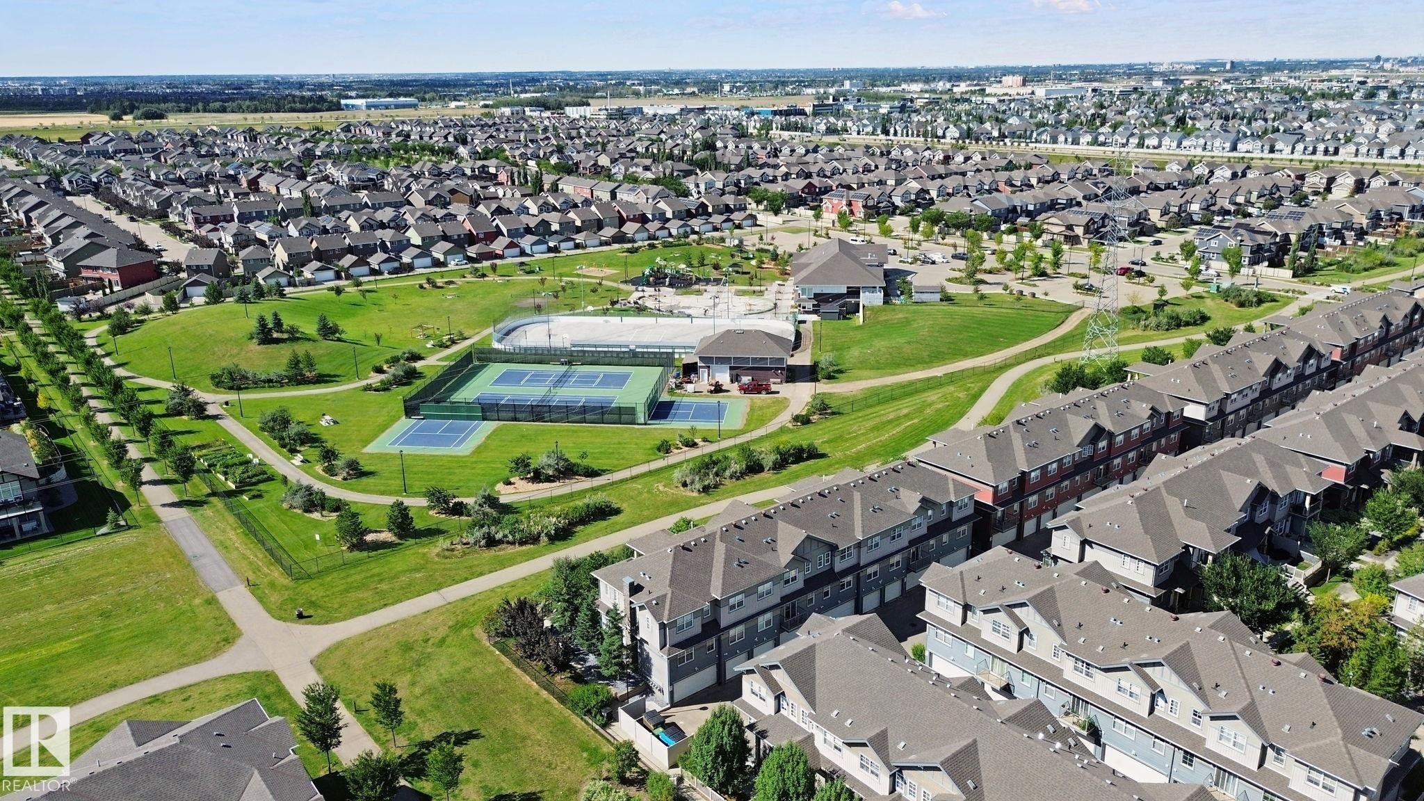 Expansive community green space with paved walking paths, multiple tennis courts, and mature landscaping - #58 4029 Orchards Dr Sw, Edmonton, AB