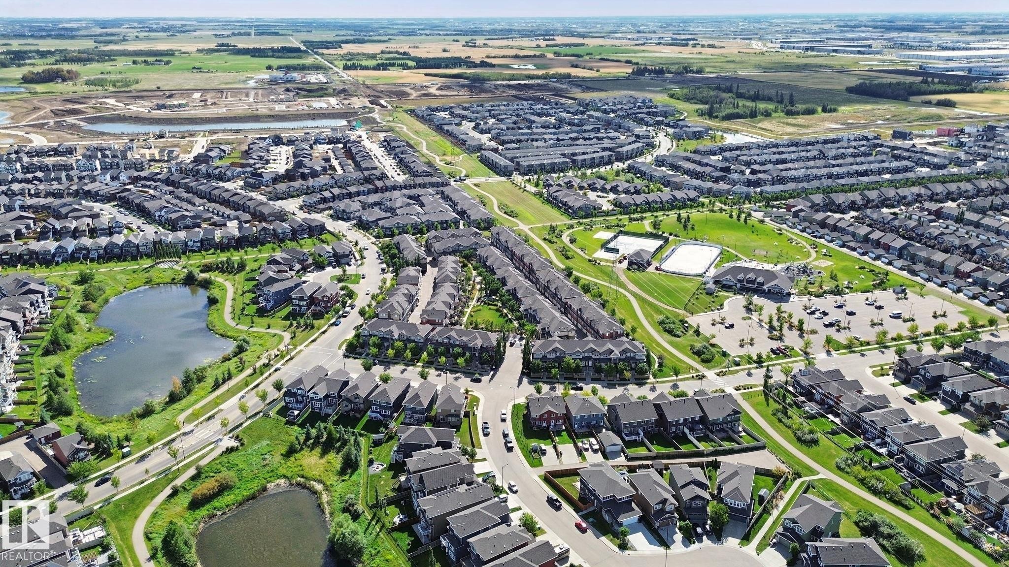 Expansive residential community featuring multiple ponds, green spaces, walking paths, and recreational courts - #58 4029 Orchards Dr Sw, Edmonton, AB