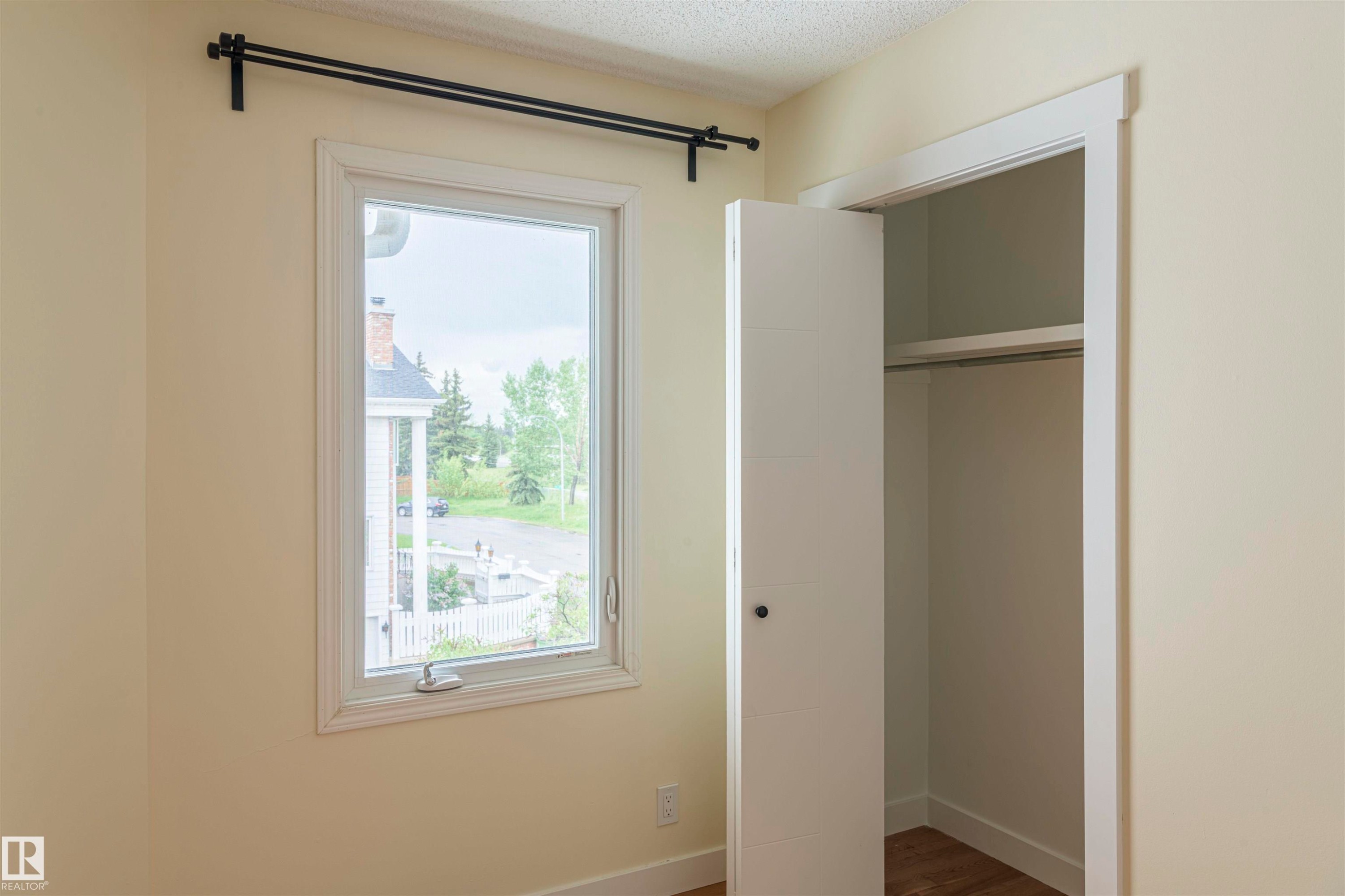 Window with black curtain rods, white trim, and a side-hinged latch - 5010 147 Street Nw, Edmonton, AB