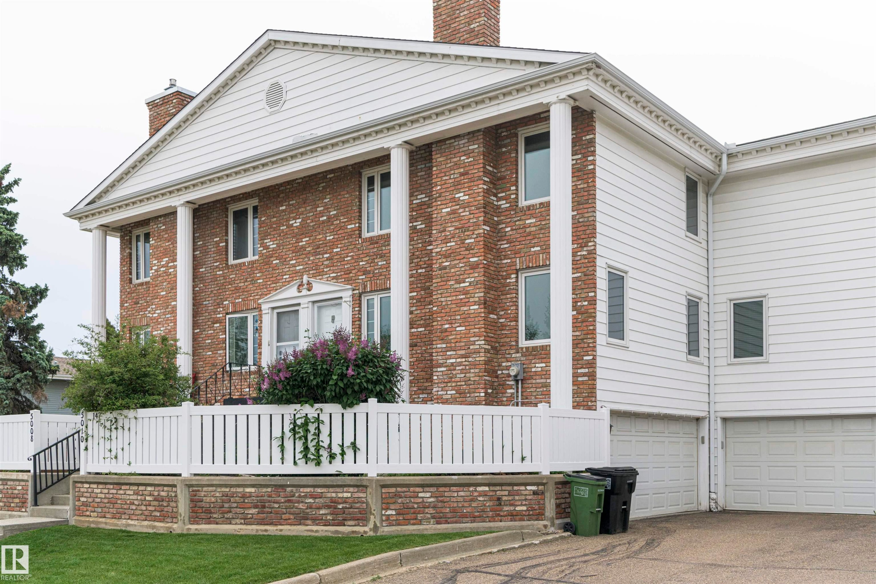 Brick and siding exterior with a prominent portico featuring four columns - 5010 147 Street Nw, Edmonton, AB