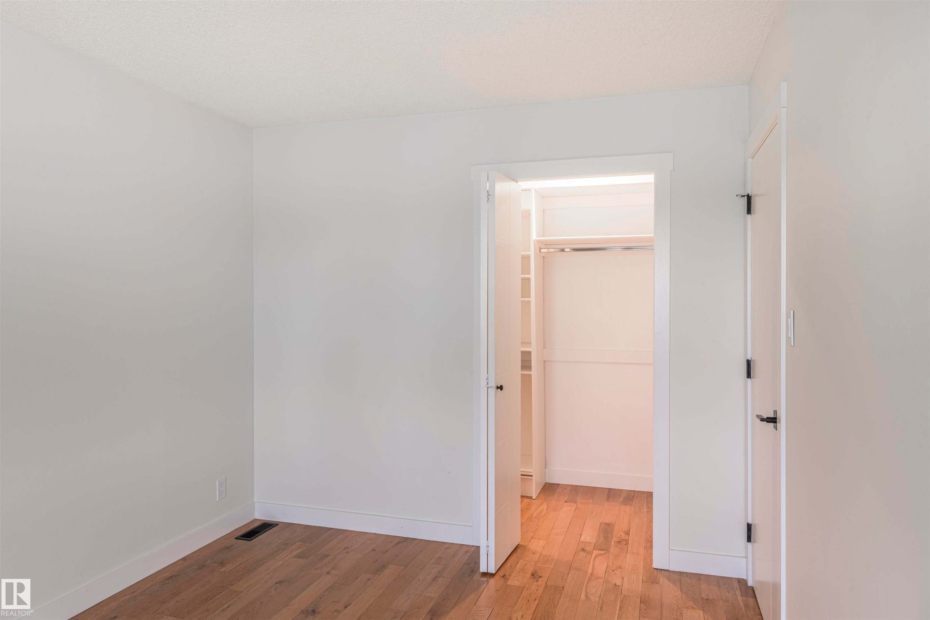 Room featuring light wood-finish flooring, white walls, and white baseboards - 5010 147 Street Nw, Edmonton, AB