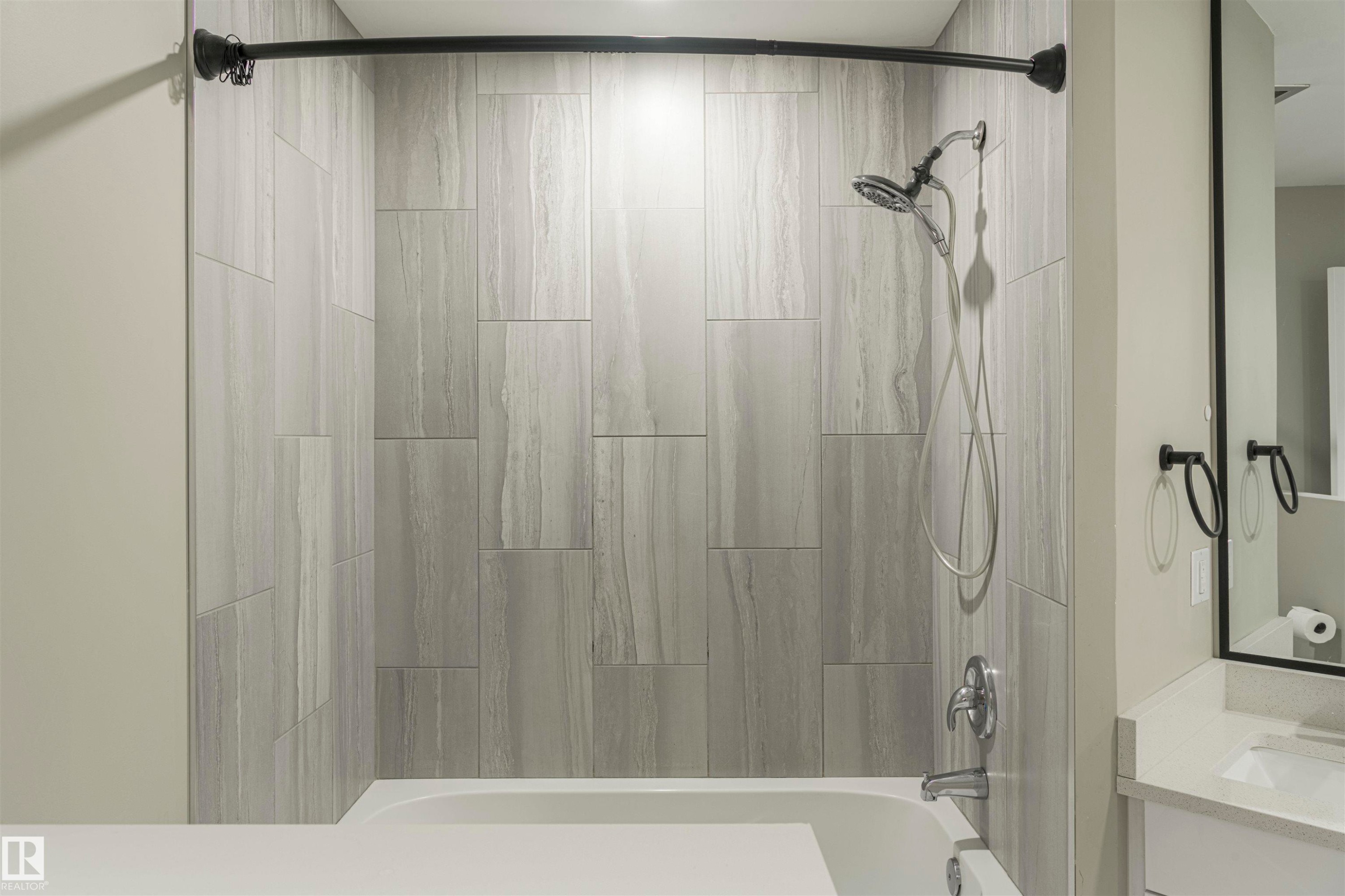 Bathtub and shower combination featuring large format tile surround - 5010 147 Street Nw, Edmonton, AB