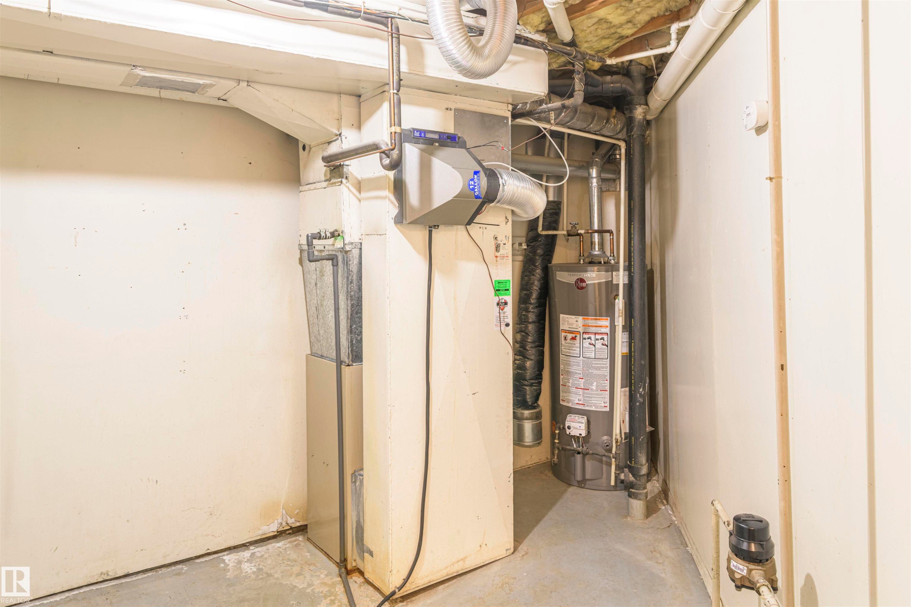 Utility area featuring a water heater, furnace system, and exposed ductwork - 5010 147 Street Nw, Edmonton, AB