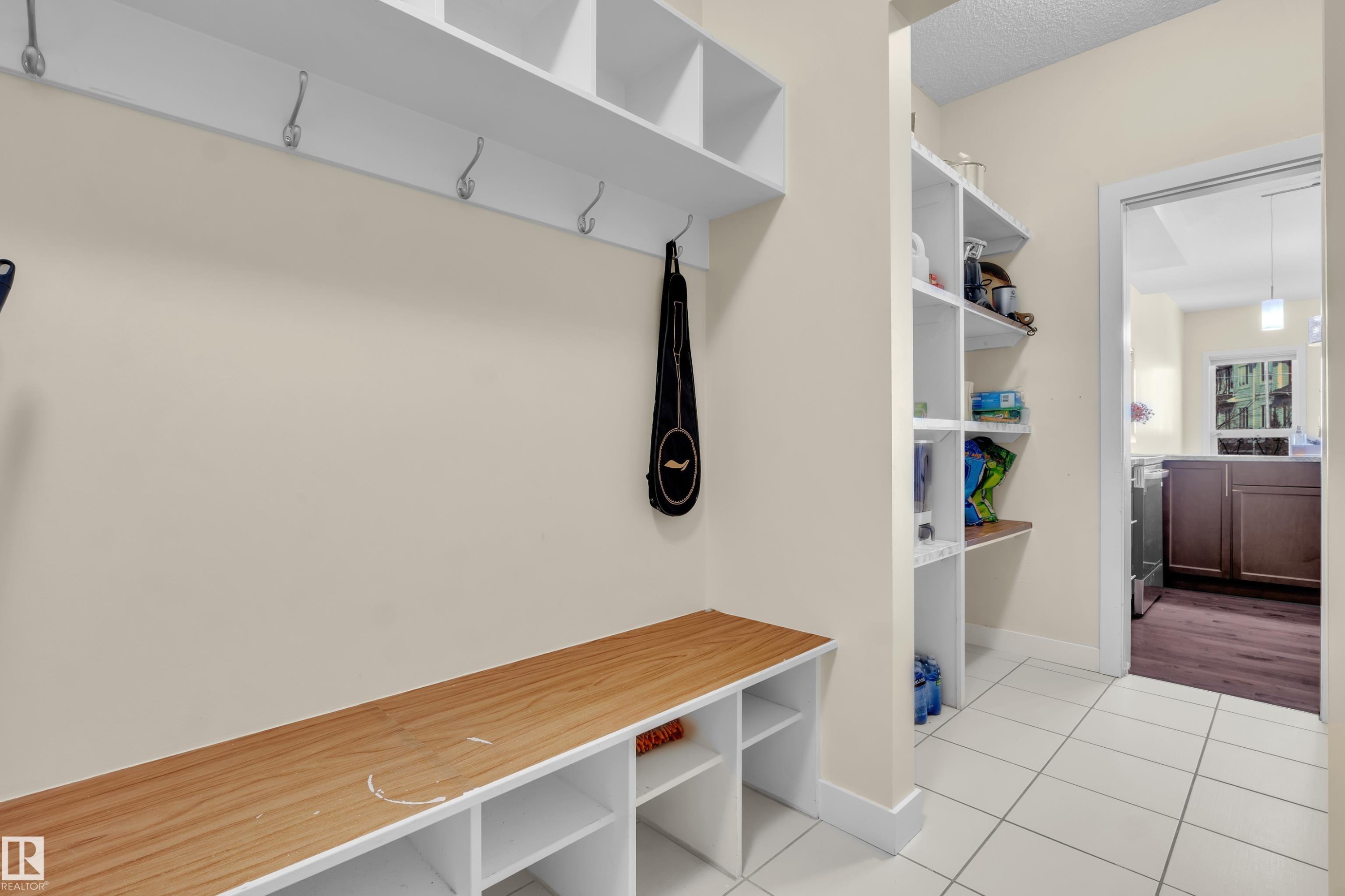Entryway featuring a built-in bench with wood-finish top and cubby storage - 3071 Carpenter Landing Sw, Edmonton, AB