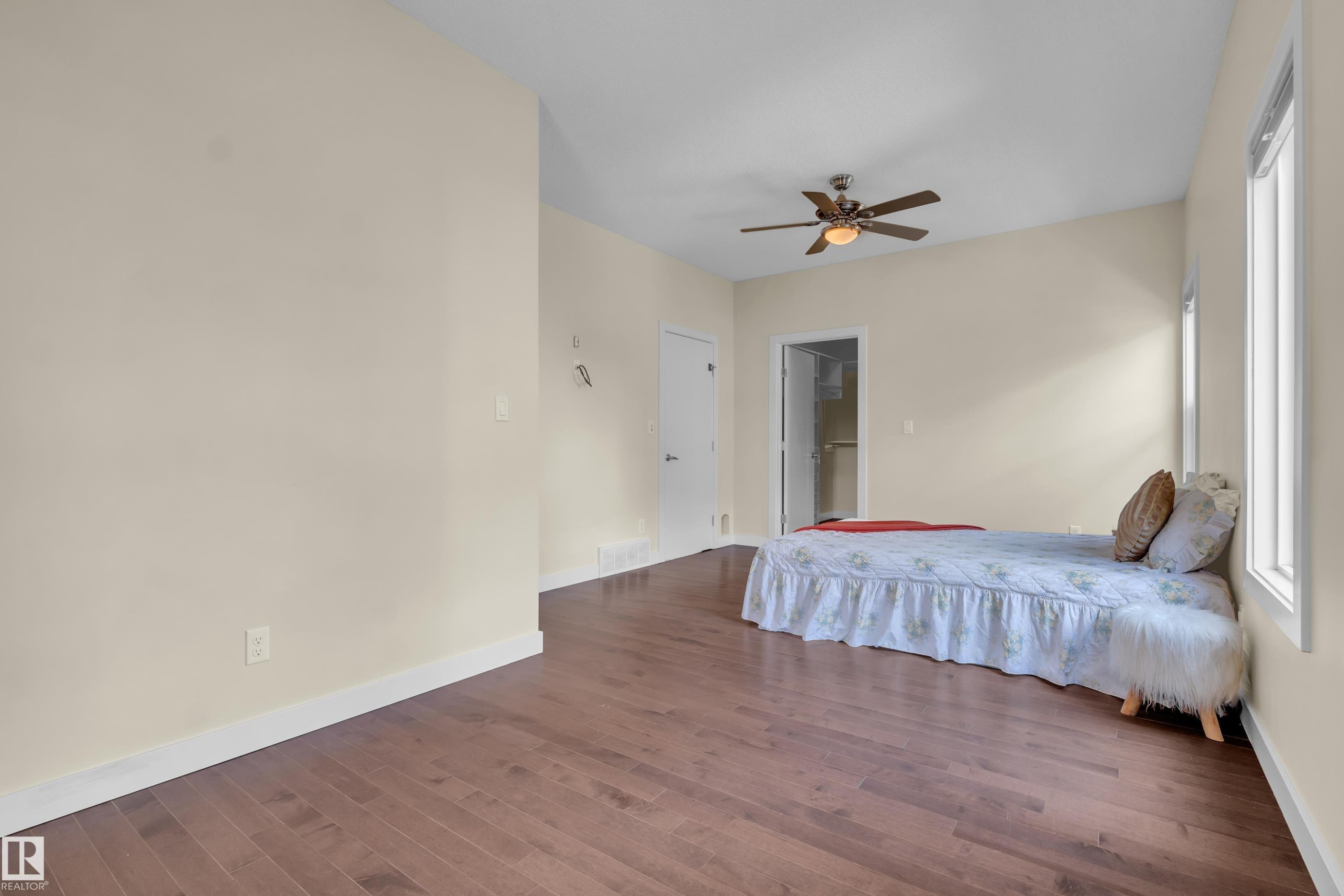Spacious interior room featuring wood-finish flooring, light-toned walls, and a ceiling fan - 3071 Carpenter Landing Sw, Edmonton, AB