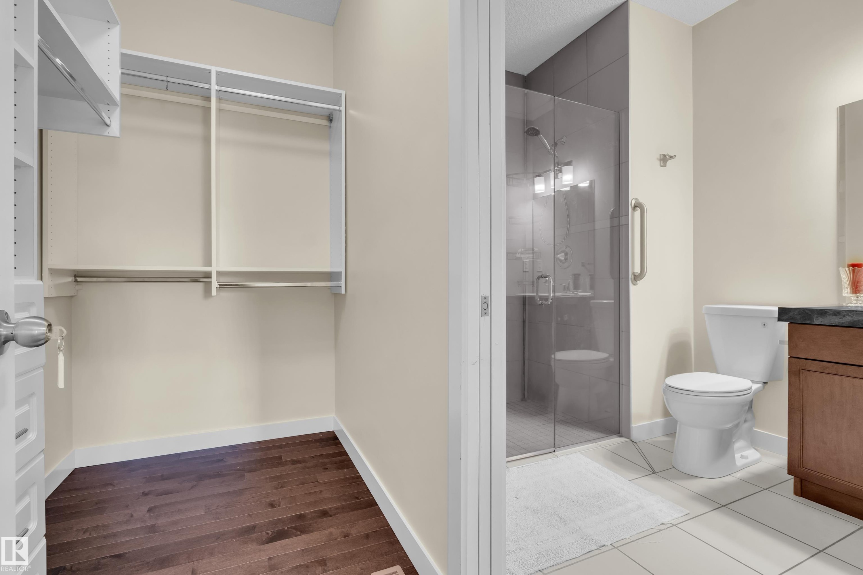 Walk-in closet featuring wood-finish flooring and integrated shelving - 3071 Carpenter Landing Sw, Edmonton, AB