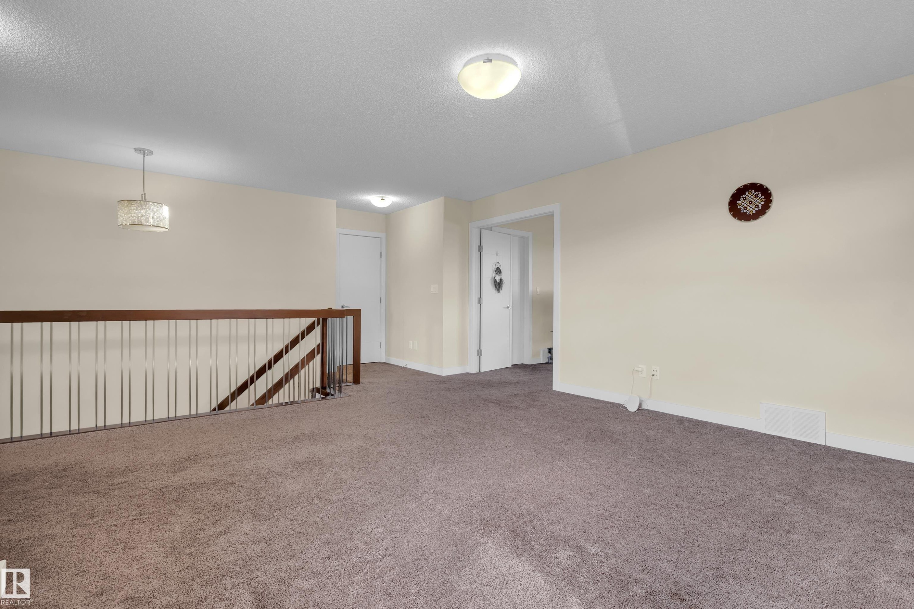 Upper level landing featuring neutral carpeting, light cream wall paint, and a white ceiling - 3071 Carpenter Landing Sw, Edmonton, AB