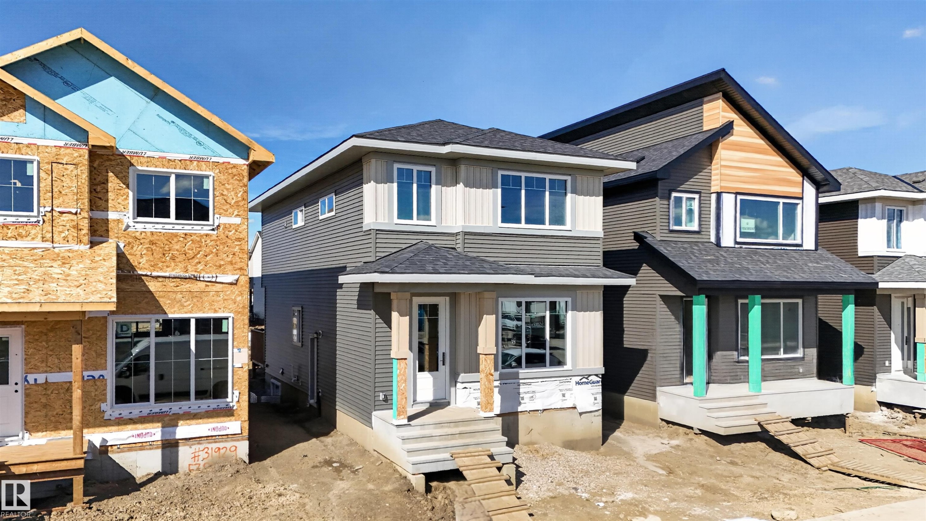 Two-story residence featuring a gray and beige exterior, multiple windows, and a front entry with steps - 55 Rosa Crescent, St. Albert, AB