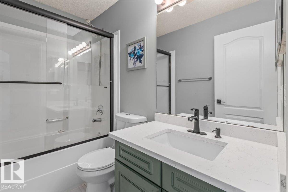 Bathroom featuring a single vanity with a white countertop, a rectangular undermount sink, and a dark bronze faucet - 15420 44 Street Nw, Edmonton, AB