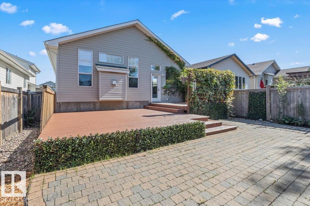Expansive paver patio with a raised wood-finish deck - 15420 44 Street Nw, Edmonton, AB