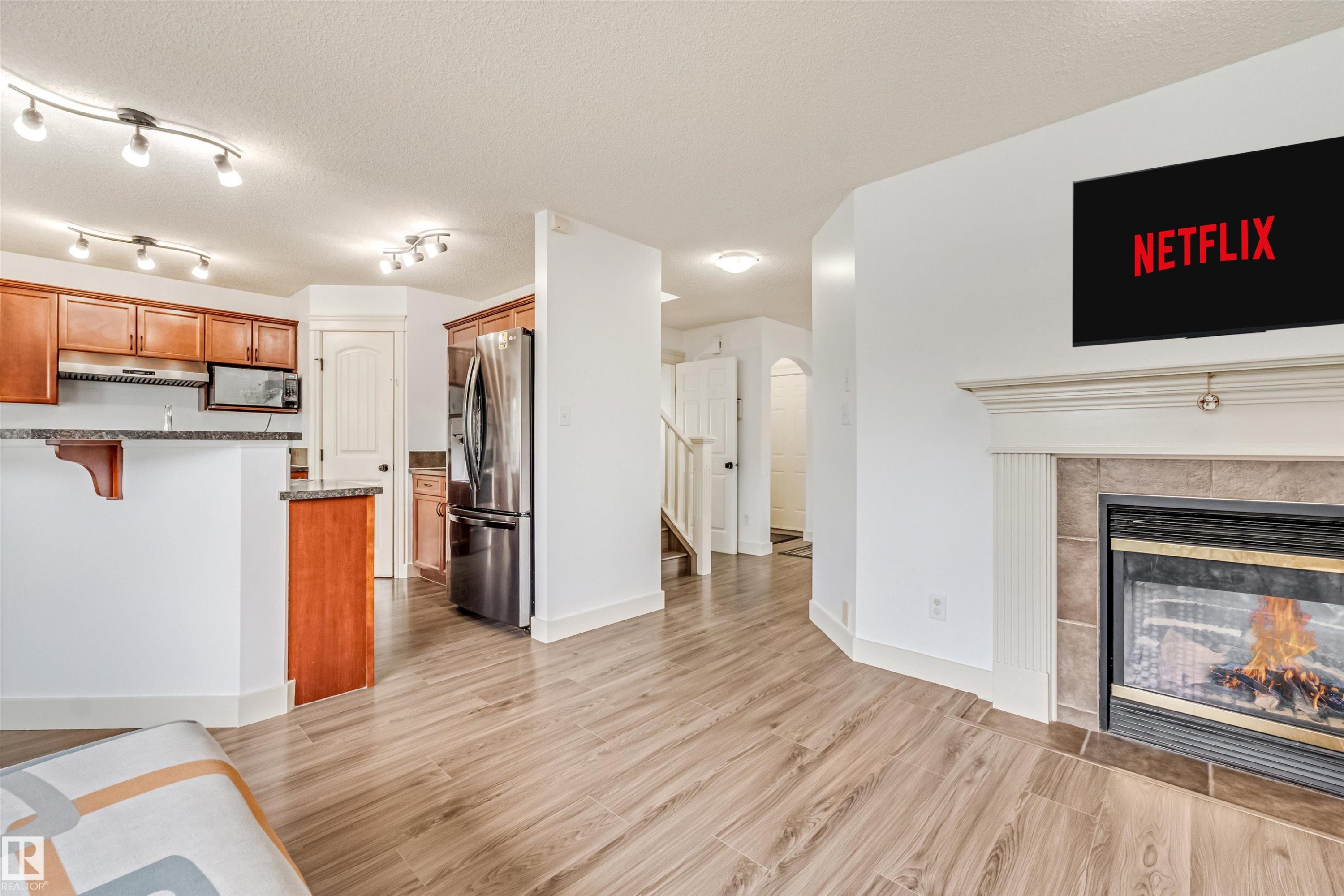 Kitchen featuring wood cabinetry, stainless steel appliances, and track lighting - 20324 48 Avenue Nw, Edmonton, AB