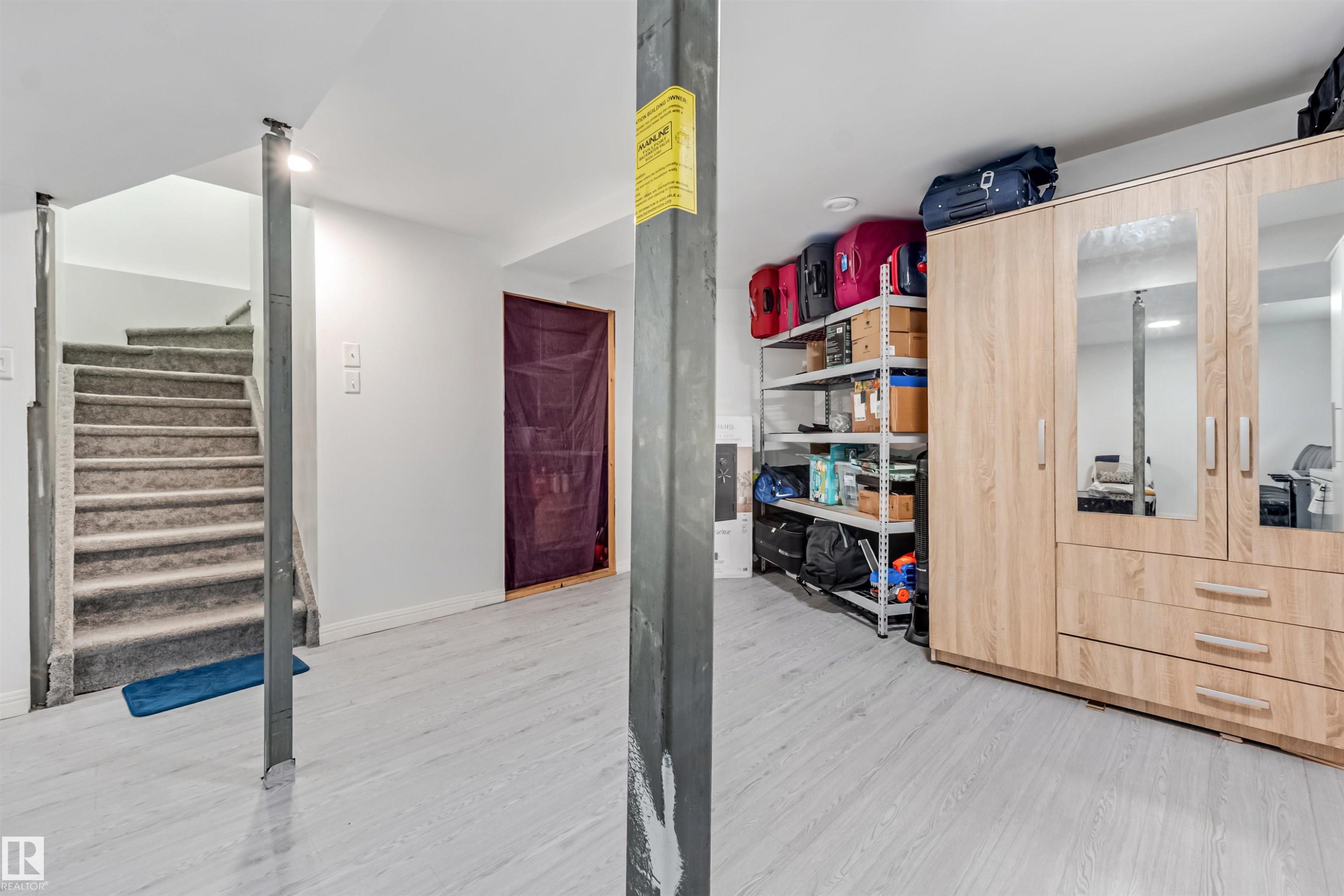 Light wood-finish flooring with a carpeted staircase - 20324 48 Avenue Nw, Edmonton, AB