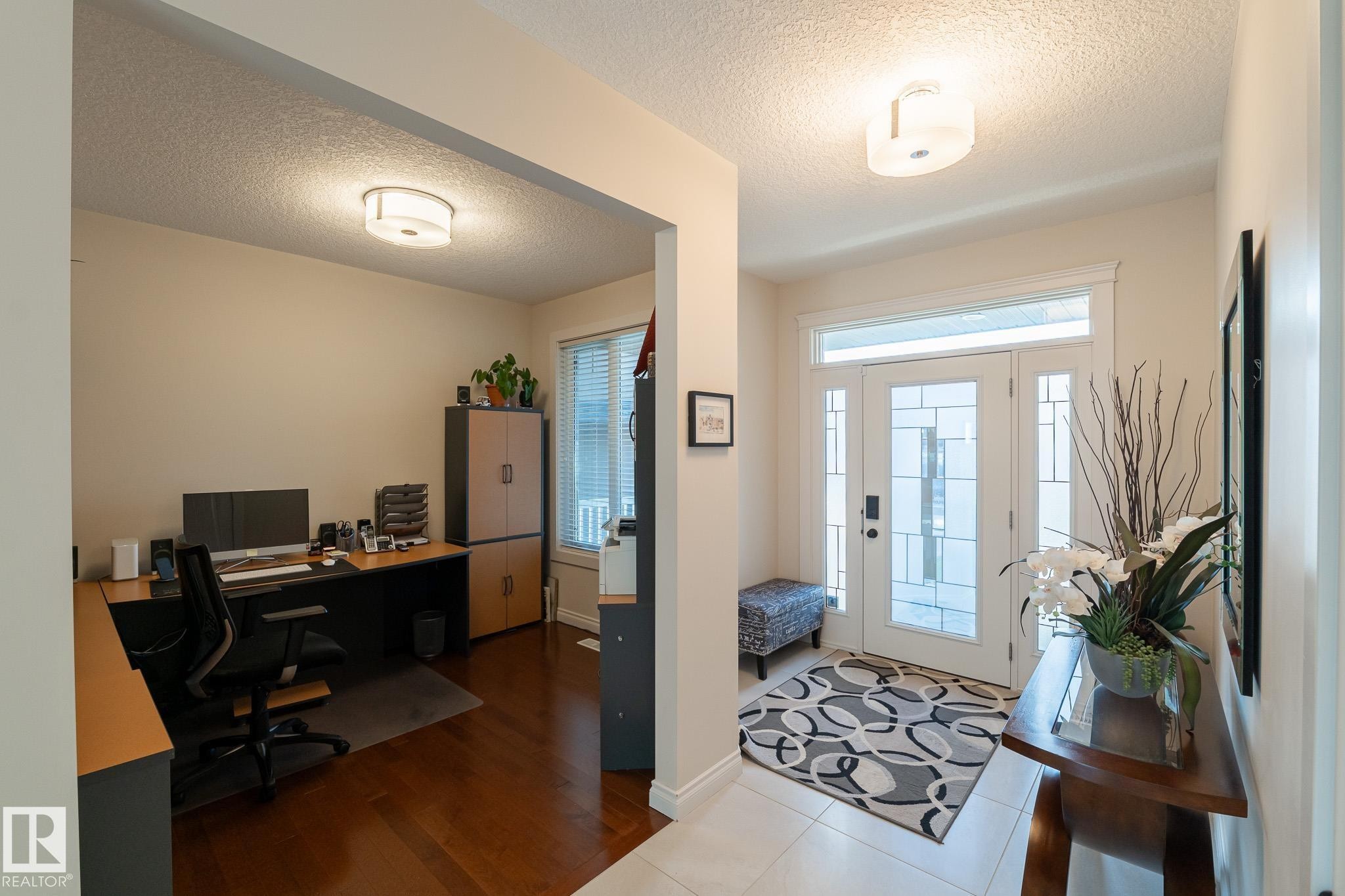 Entryway with white tile flooring and a decorative glass paneled door - 914 Crystallina Nera Way Nw, Edmonton, AB
