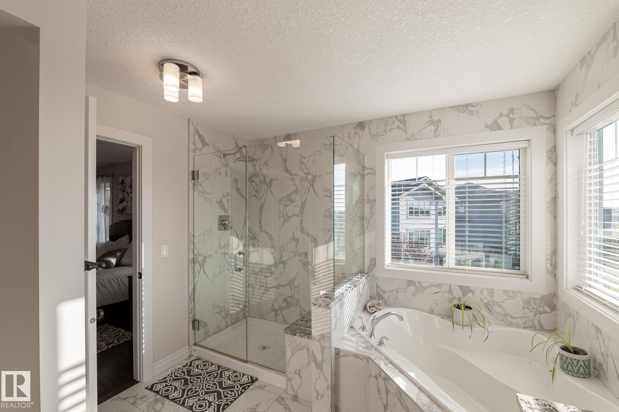 Glass-enclosed shower, built-in soaking tub, large window, tile flooring, and wall tile - 914 Crystallina Nera Way Nw, Edmonton, AB