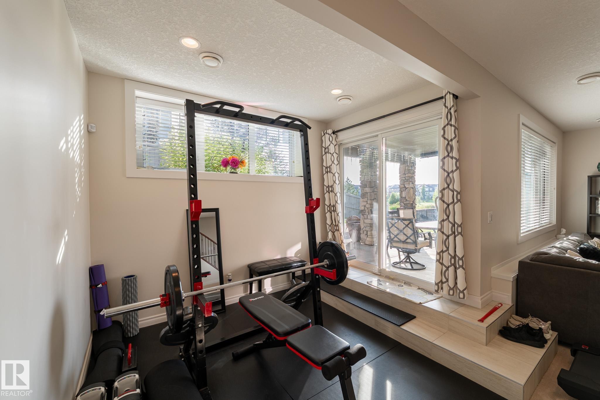 Recessed lighting illuminates this space, featuring a sliding glass door with a transom window above - 914 Crystallina Nera Way Nw, Edmonton, AB