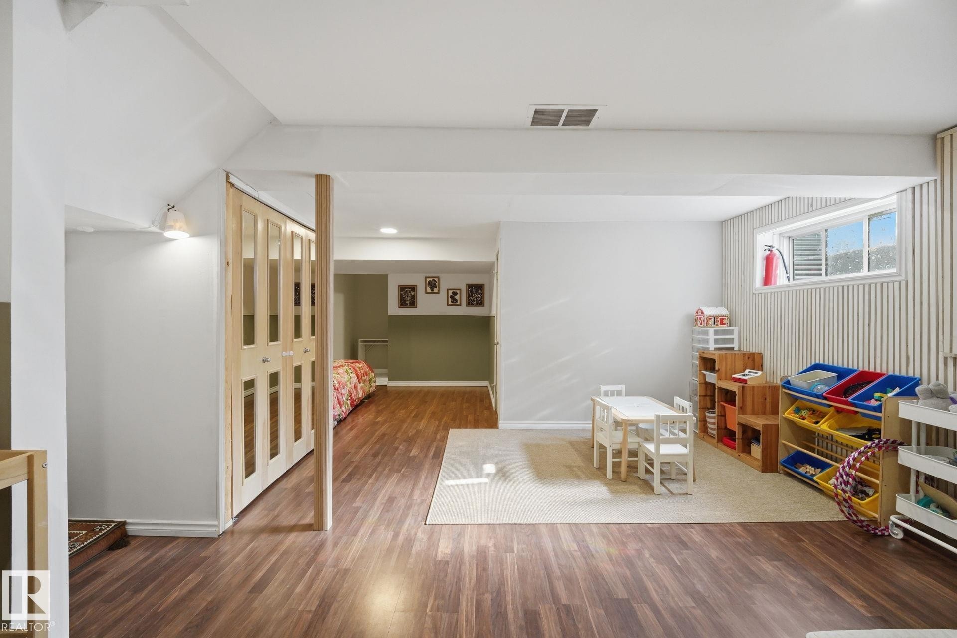 Lower level featuring wood-finish flooring - 17621 10 Avenue Sw, Edmonton, AB - Indoor Photo Showing Other Room