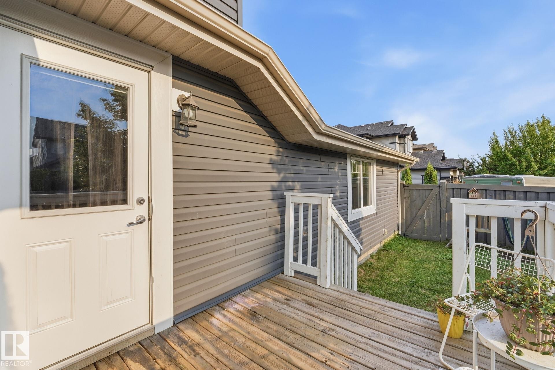Wood-finish decking with white railing and steps - 17621 10 Avenue Sw, Edmonton, AB - Outdoor With Exterior