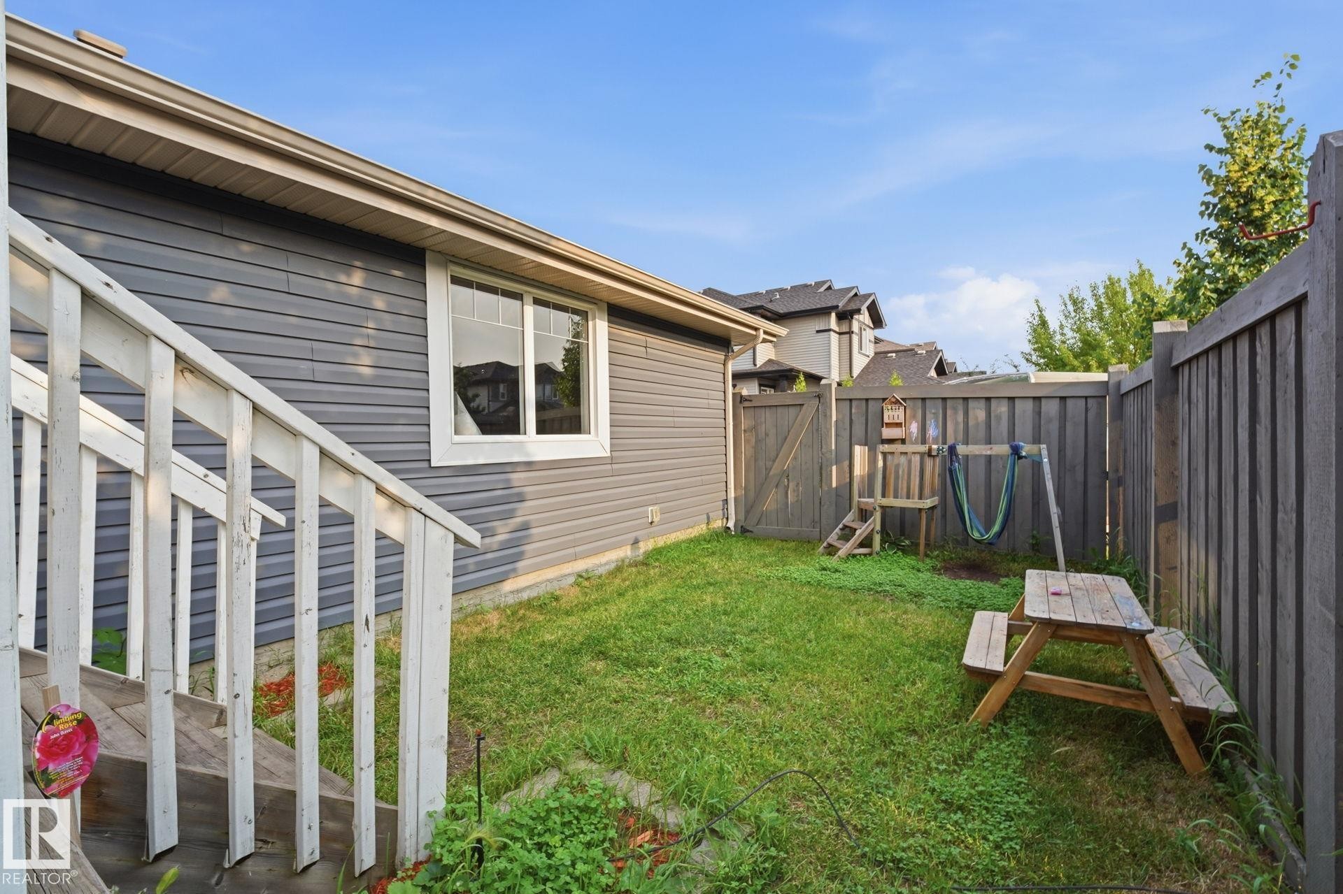 Private fenced backyard featuring gate access, and a wooden fence - 17621 10 Avenue Sw, Edmonton, AB - Outdoor