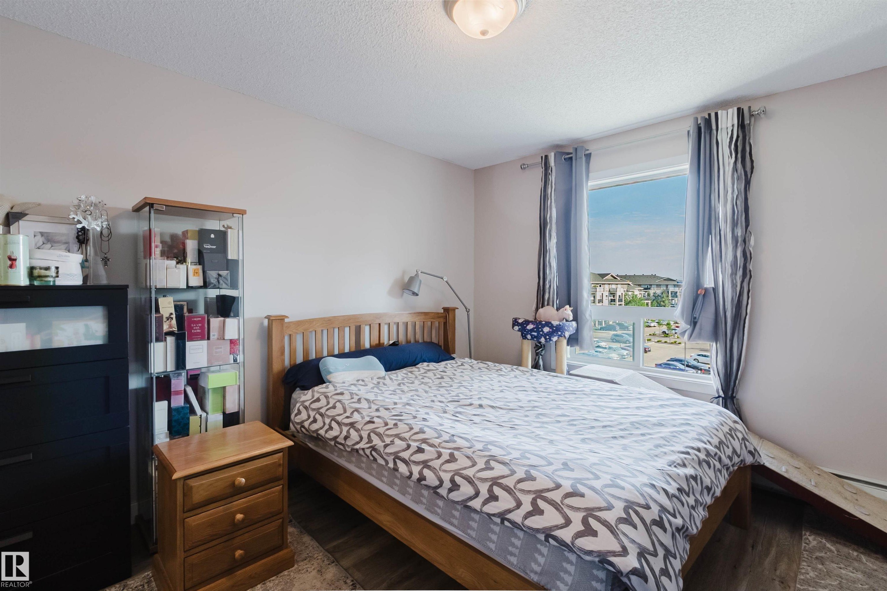 Bright room featuring a large window, recessed lighting, and wood-finish flooring - #7428 7327 South Terwillegar Dr Nw, Edmonton, AB