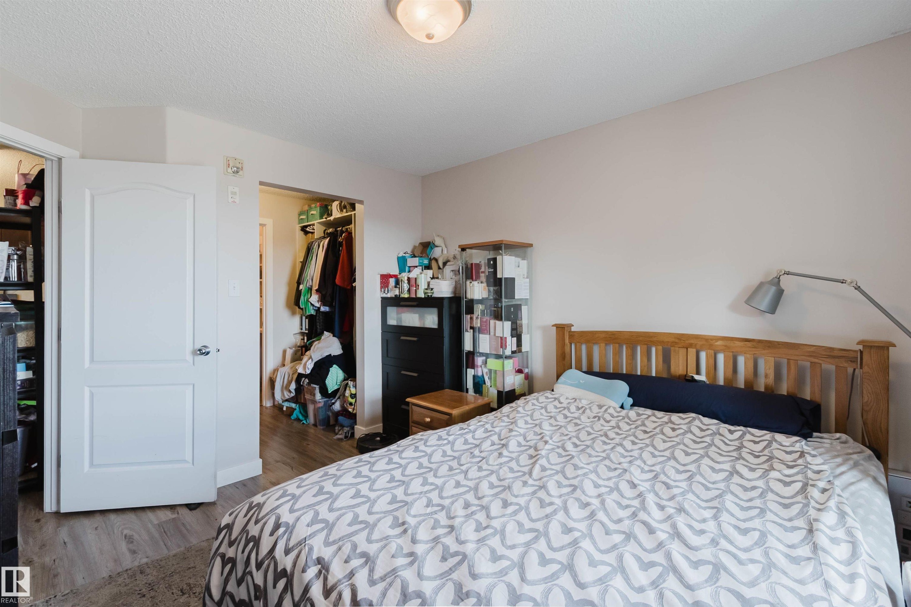 Neutral wall tones, wood-finish flooring, white paneled doors, and ceiling-mounted light fixture - #7428 7327 South Terwillegar Dr Nw, Edmonton, AB