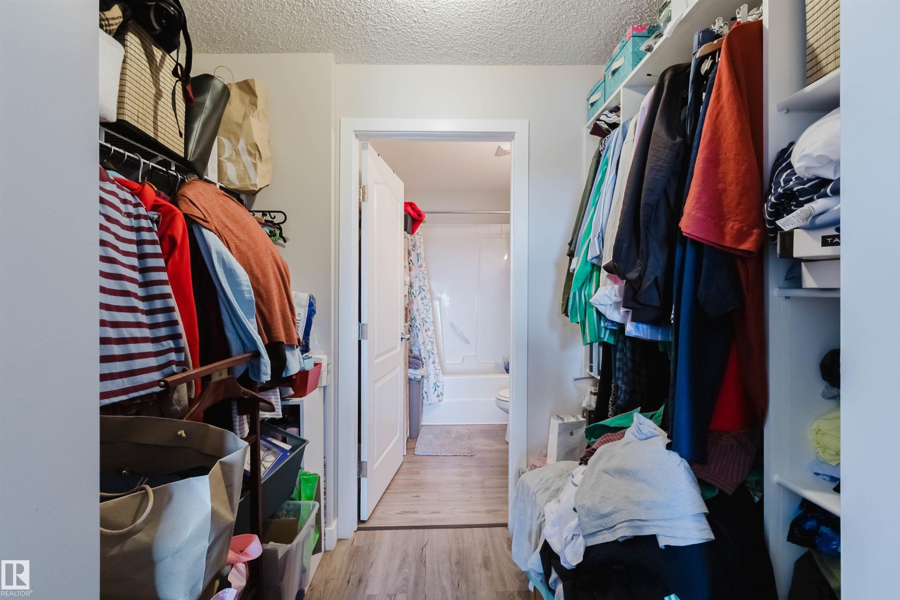 Walk-in closet with built-in shelving, hanging rods, and wood-finish flooring - #7428 7327 South Terwillegar Dr Nw, Edmonton, AB