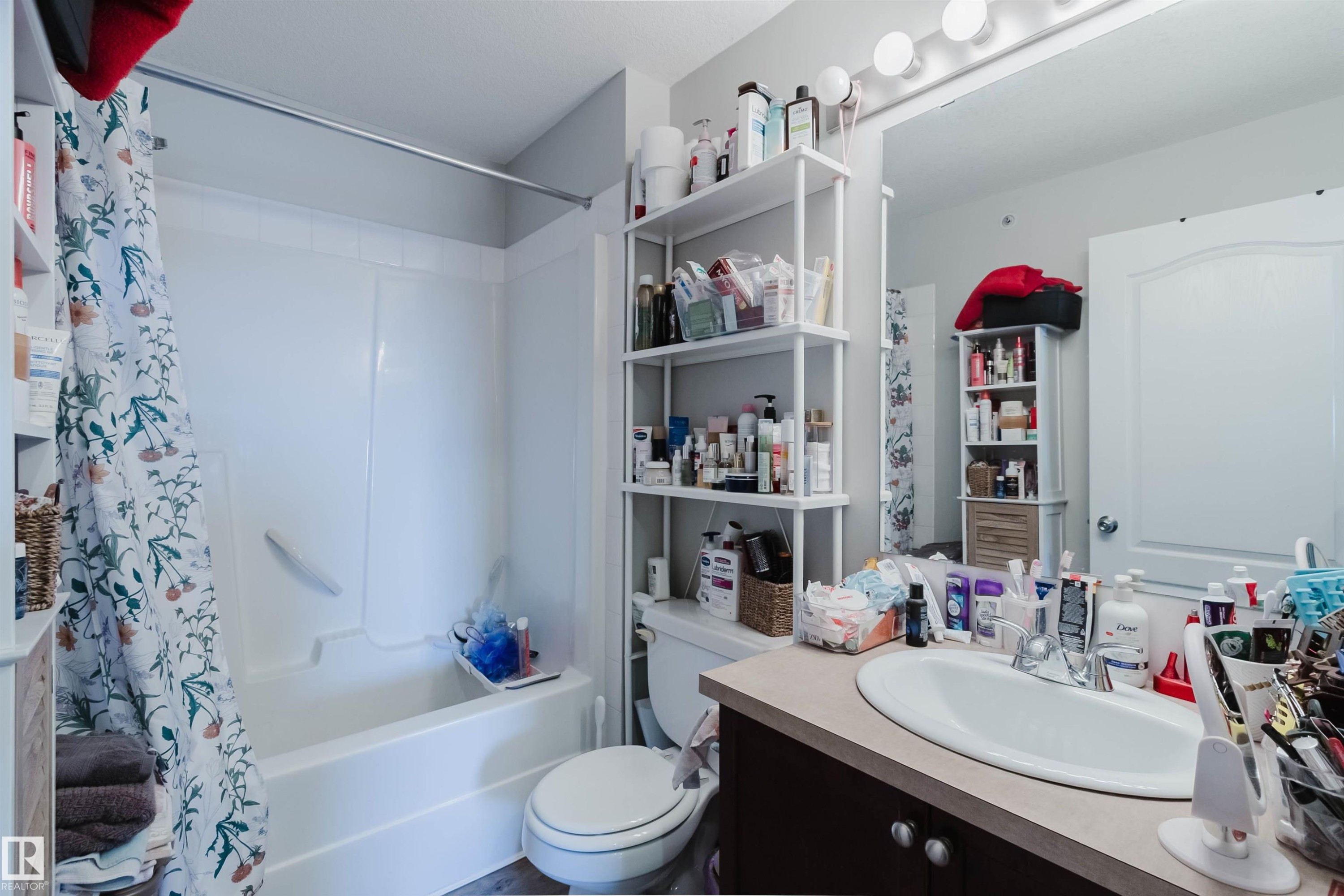 Bathroom featuring a white bathtub/shower combination, a vanity with an integrated sink, and an overhead light fixture - #7428 7327 South Terwillegar Dr Nw, Edmonton, AB