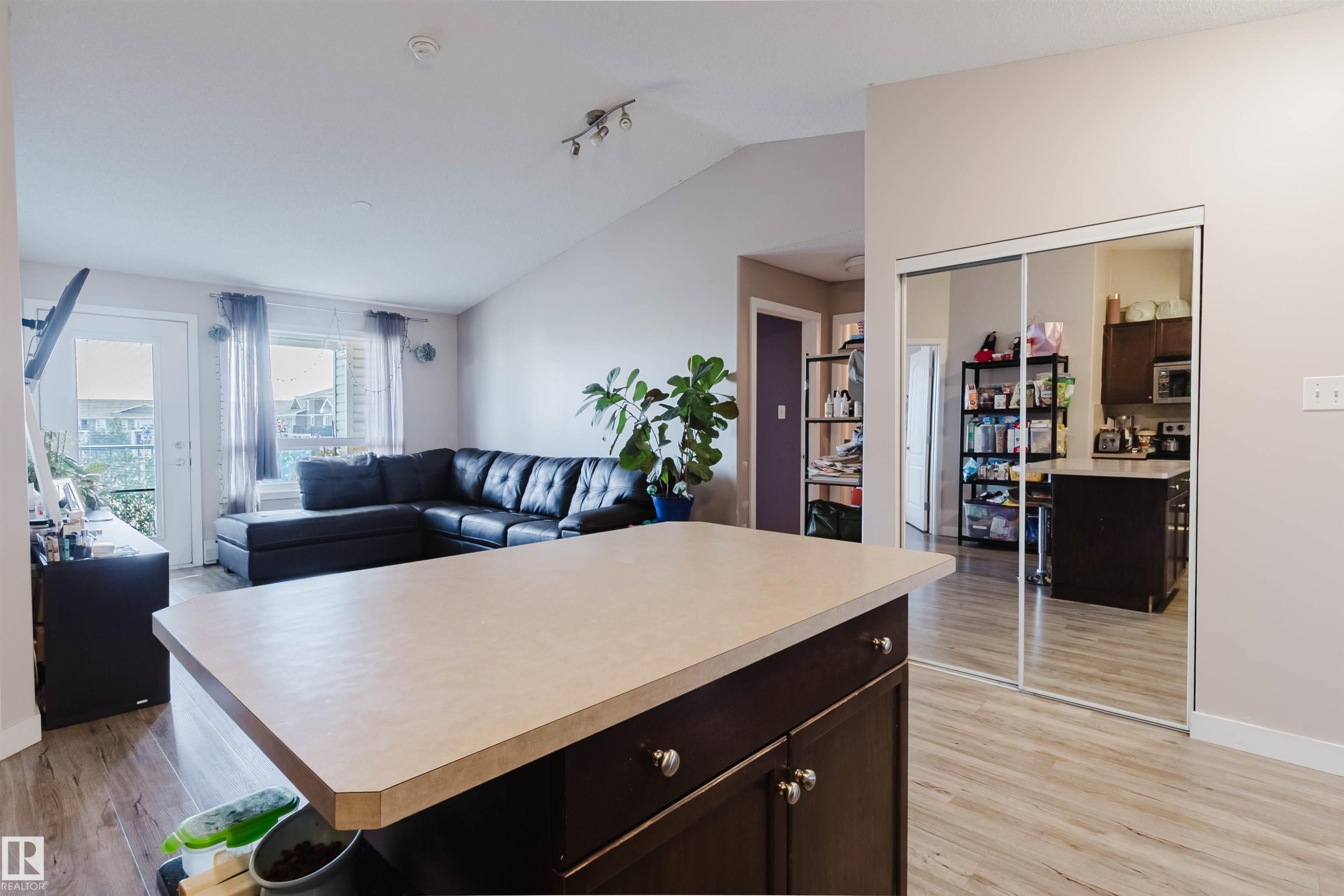 Kitchen island with integrated cabinetry and light-colored countertop - #7428 7327 South Terwillegar Dr Nw, Edmonton, AB