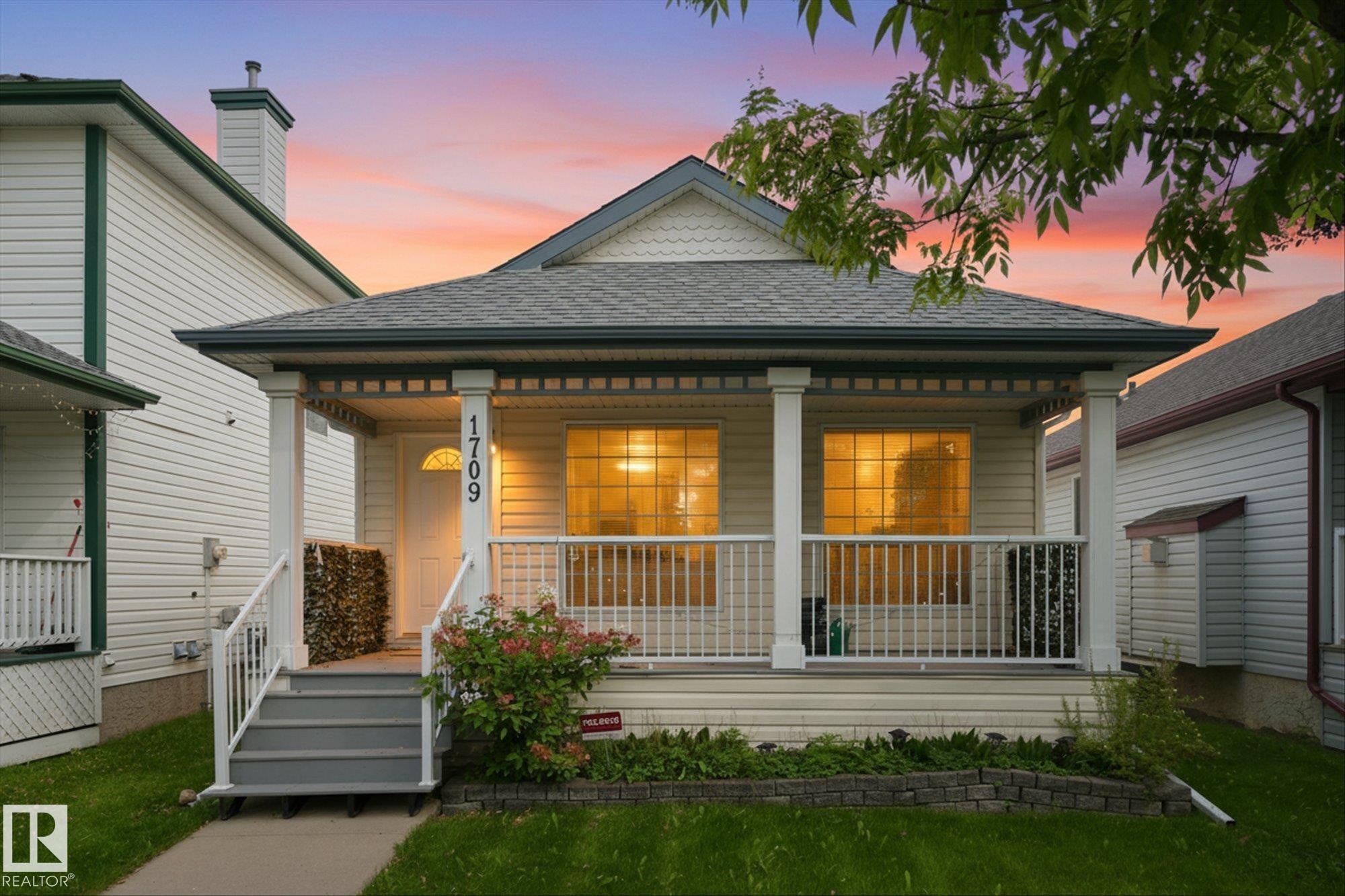 Covered front porch with white railings and columns - 1709 Turvey Bend Bend Nw, Edmonton, AB