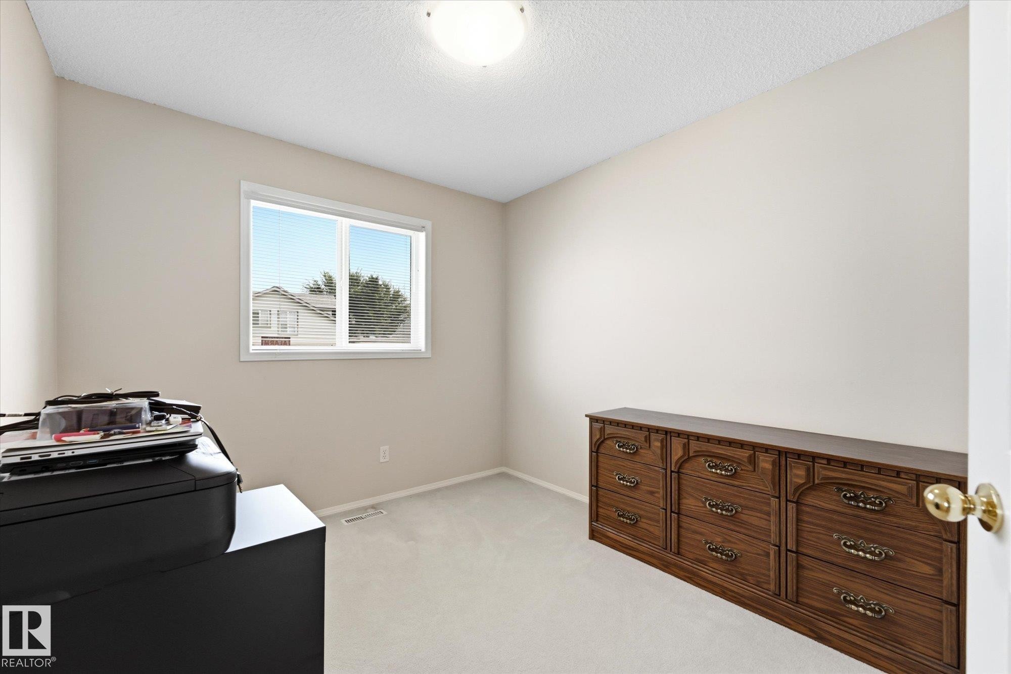 Neutral-toned walls and ceiling, light-colored carpeting, single window with white trim, flush mount ceiling light - 1709 Turvey Bend Bend Nw, Edmonton, AB