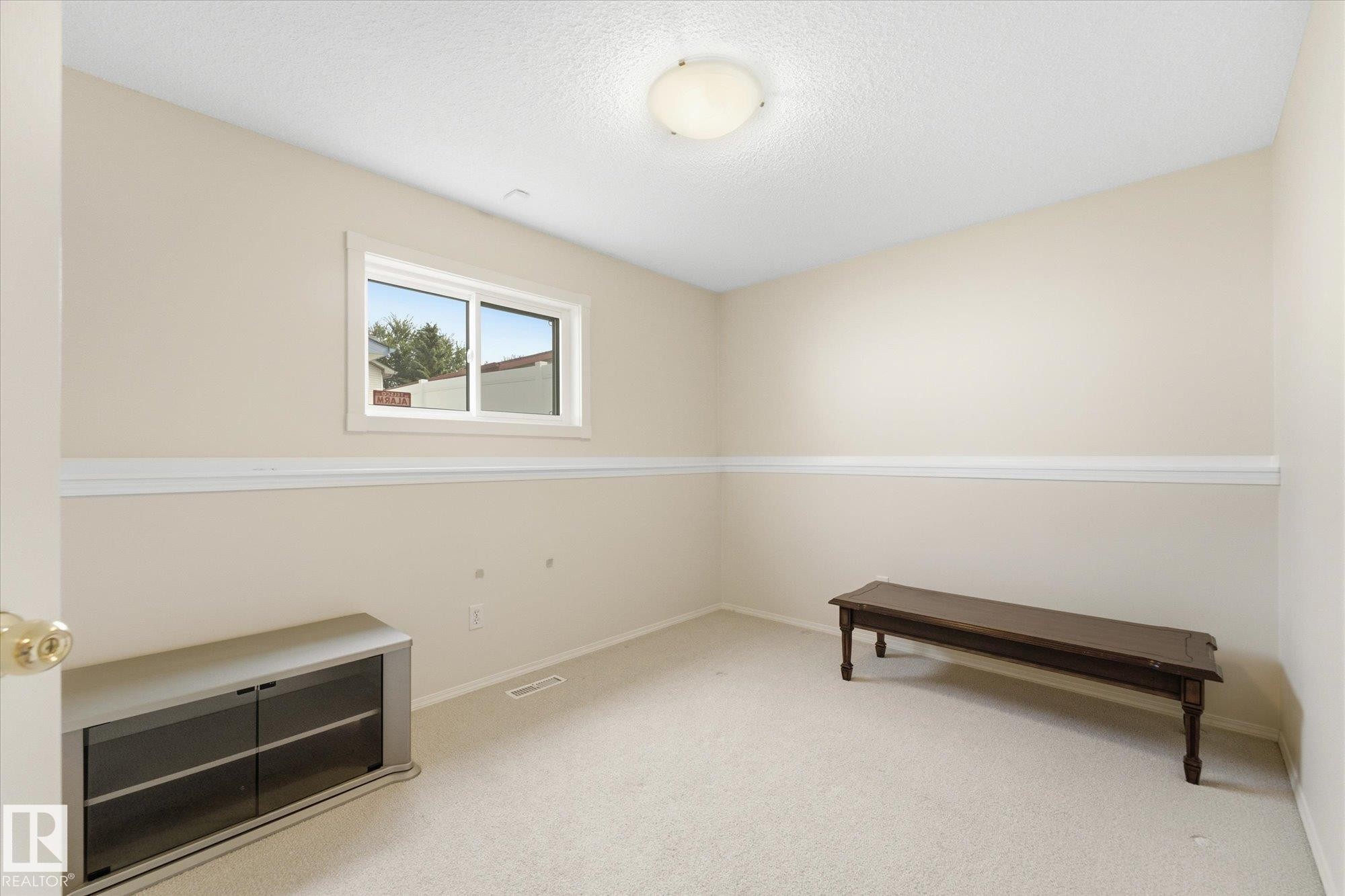 Light-colored carpeted flooring, white crown molding, white window trim, and a ceiling-mounted light fixture - 1709 Turvey Bend Bend Nw, Edmonton, AB