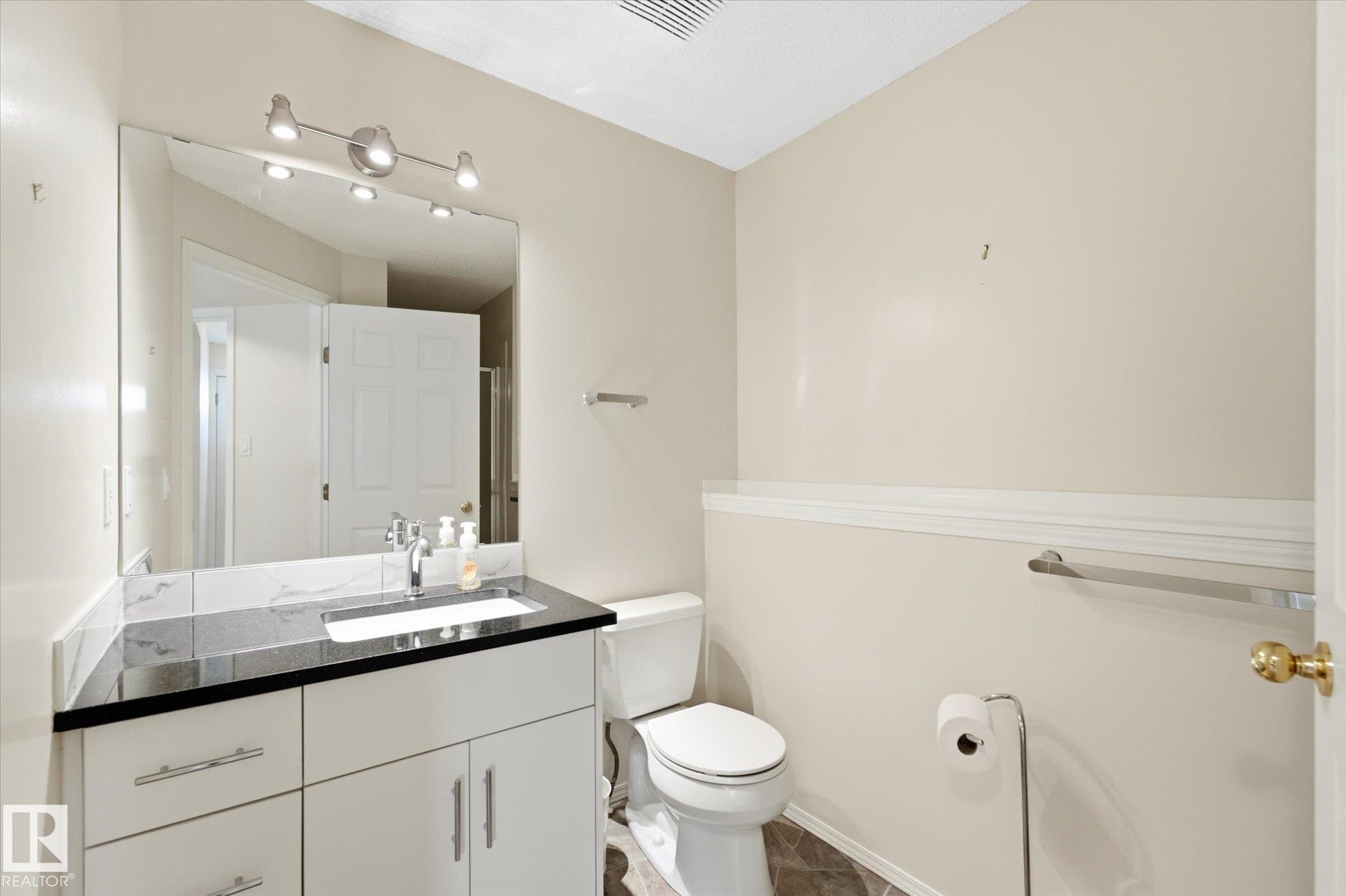 Vanity with integrated sink, black countertop, and chrome faucet - 1709 Turvey Bend Bend Nw, Edmonton, AB