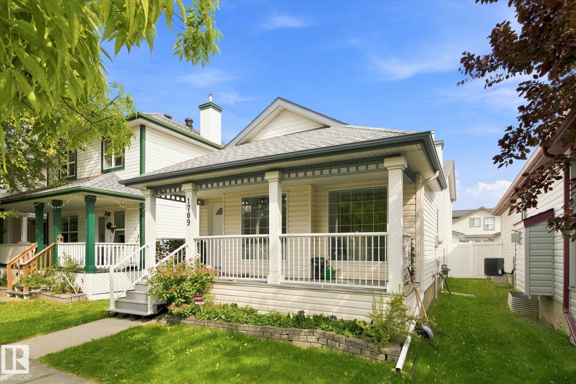 Front exterior with a covered porch, white siding, and a gabled roof - 1709 Turvey Bend Bend Nw, Edmonton, AB