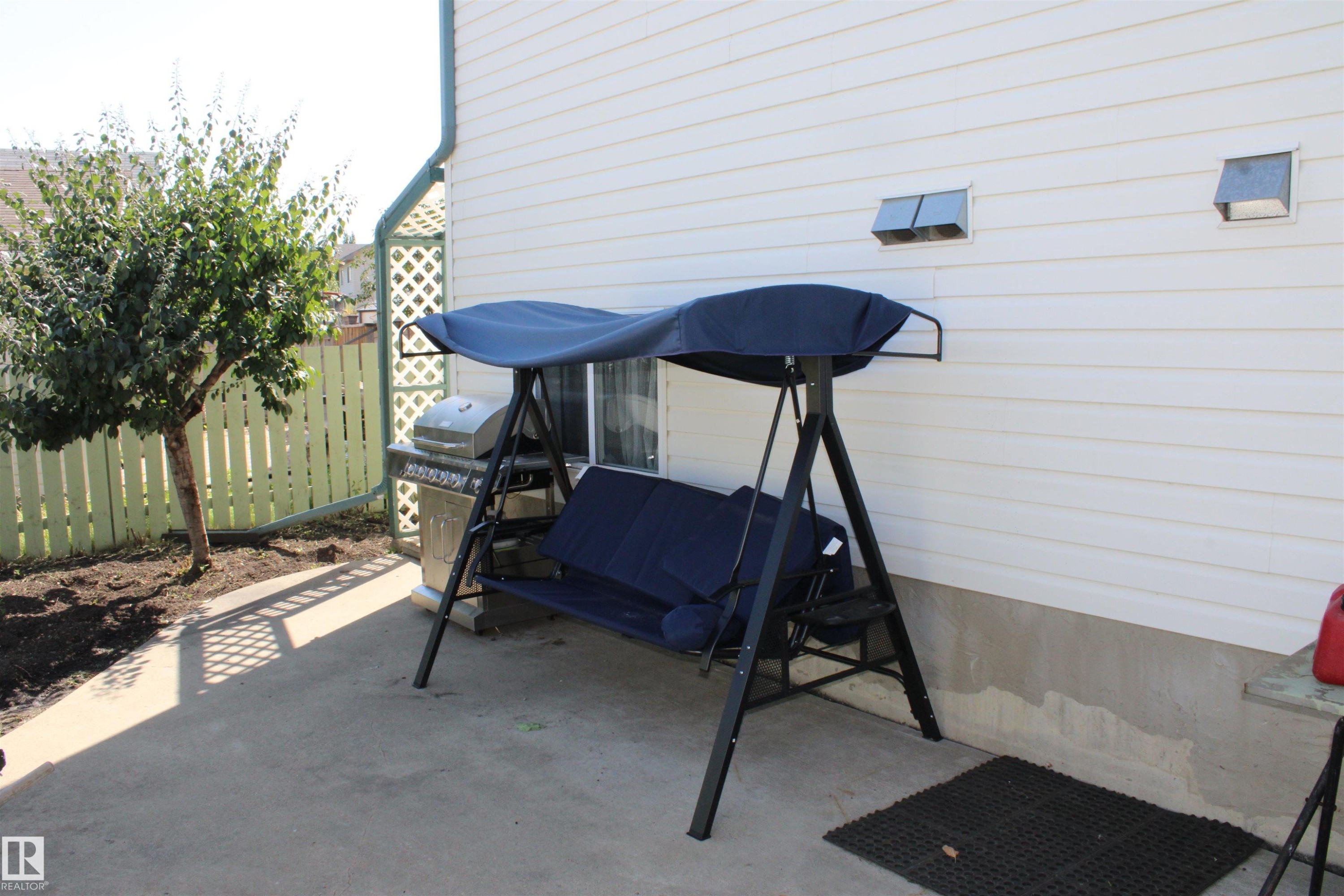 Concrete patio with white siding exterior - 15031 135 Street Nw, Edmonton, AB