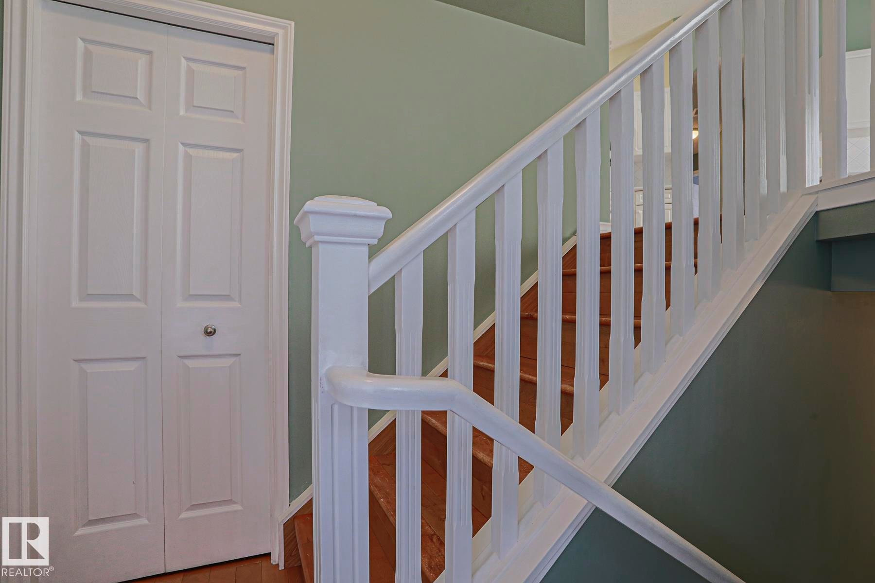 Staircase with wood-finish treads and white balusters - 15031 135 Street Nw, Edmonton, AB