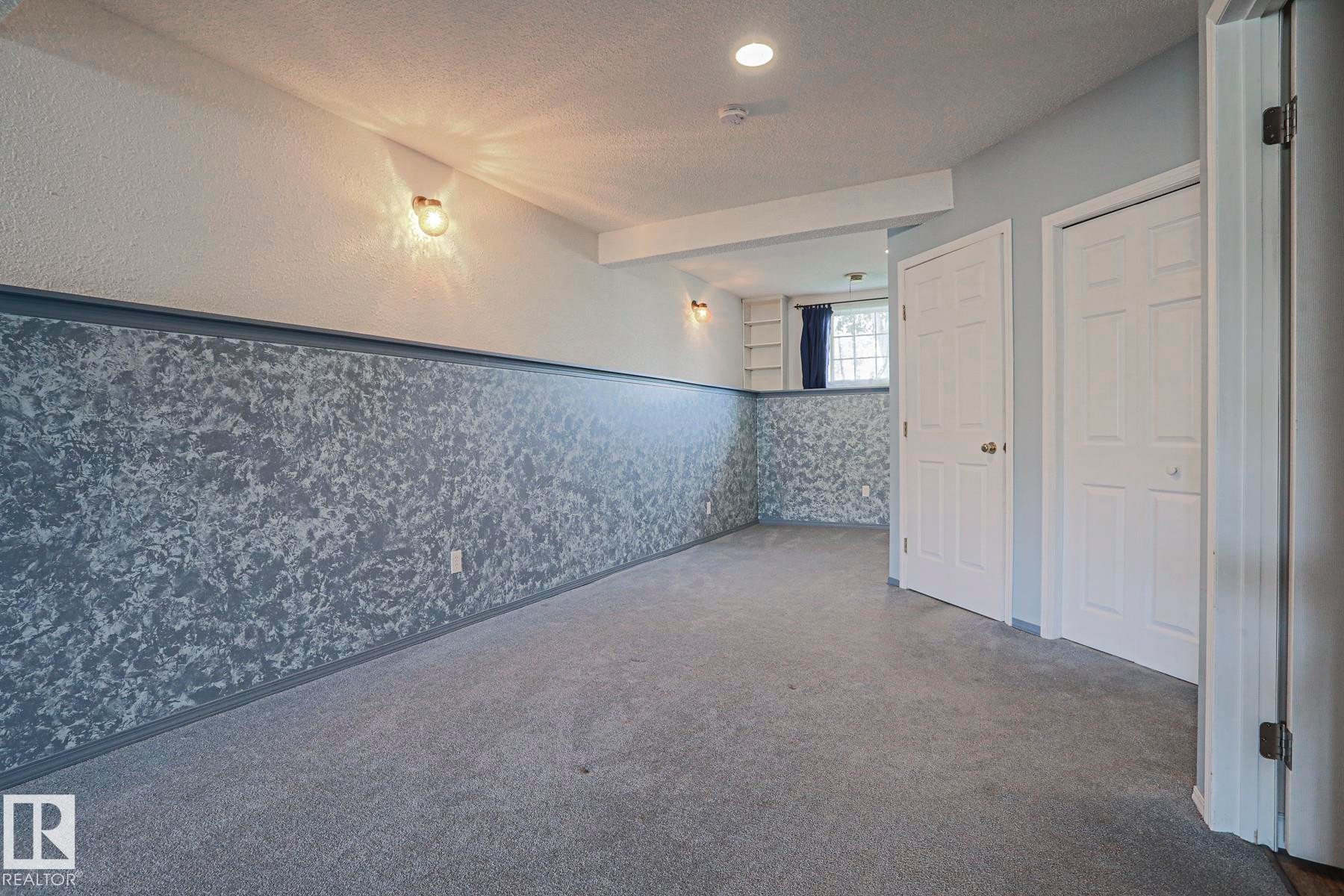 Recessed lighting and wall-mounted fixtures illuminate the space - 15031 135 Street Nw, Edmonton, AB