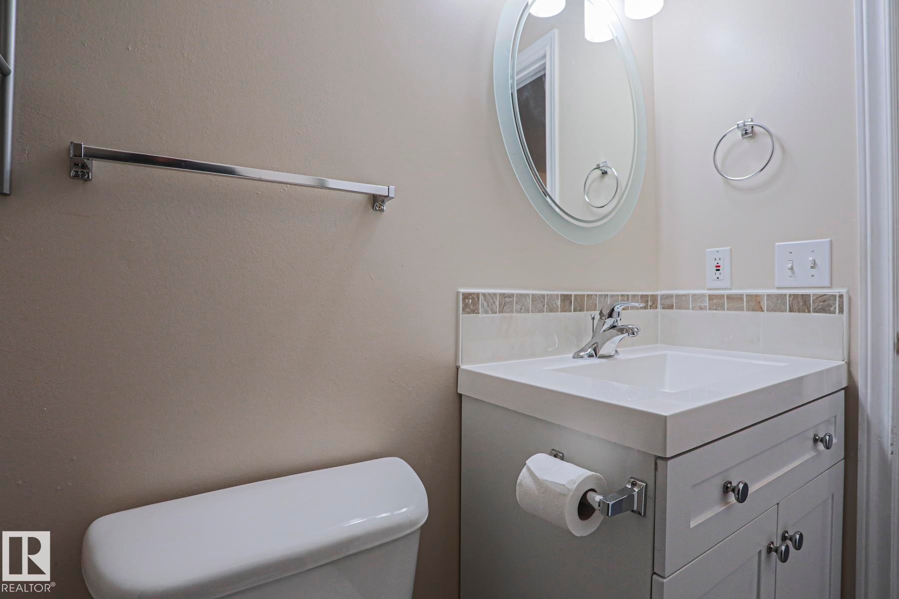 Vanity with integrated sink, chrome faucet, and white cabinetry - 15031 135 Street Nw, Edmonton, AB