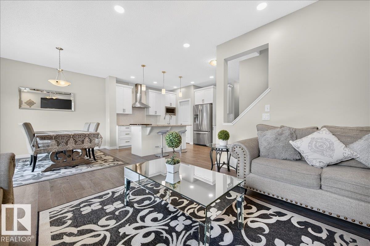 Open-concept living space featuring wood-finish flooring, recessed lighting, and a neutral color palette - 2709 Collins Crescent Sw, Edmonton, AB - Indoor Photo Showing Living Room