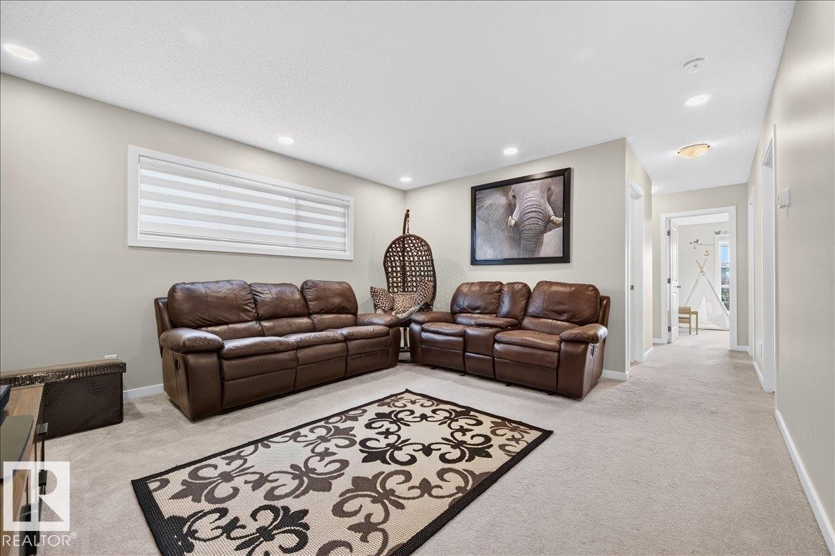 Carpeted entertainment area featuring recessed lighting, a wide horizontal window with blinds, and neutral-toned wall paint - 2709 Collins Crescent Sw, Edmonton, AB - Indoor Photo Showing Living Room