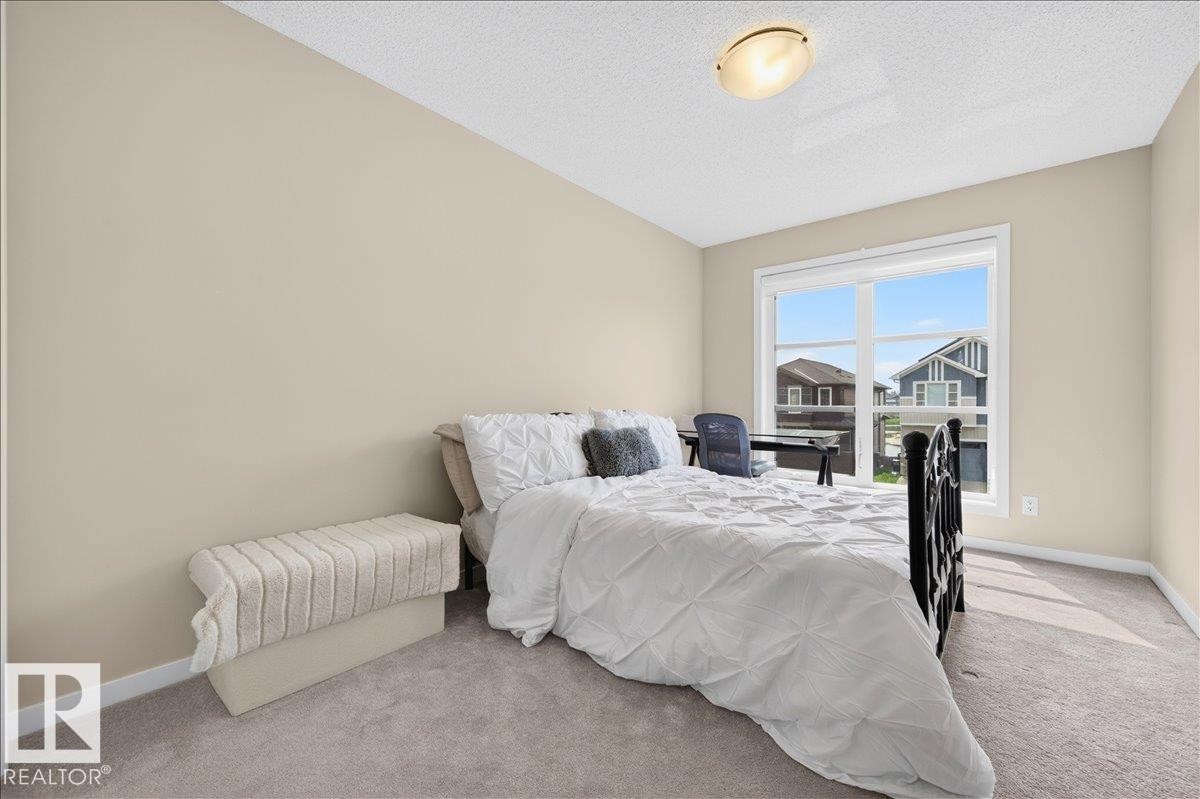 Interior room featuring a large window, neutral wall paint, and light-colored carpeting - 2709 Collins Crescent Sw, Edmonton, AB - Indoor Photo Showing Bedroom