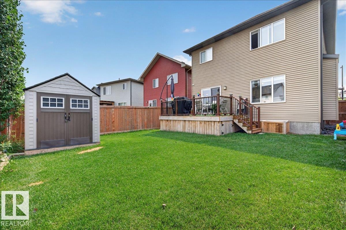 Spacious backyard featuring a substantial lawn, a built-in storage shed, and a privacy fence - 2709 Collins Crescent Sw, Edmonton, AB - Outdoor With Deck Patio Veranda With Exterior