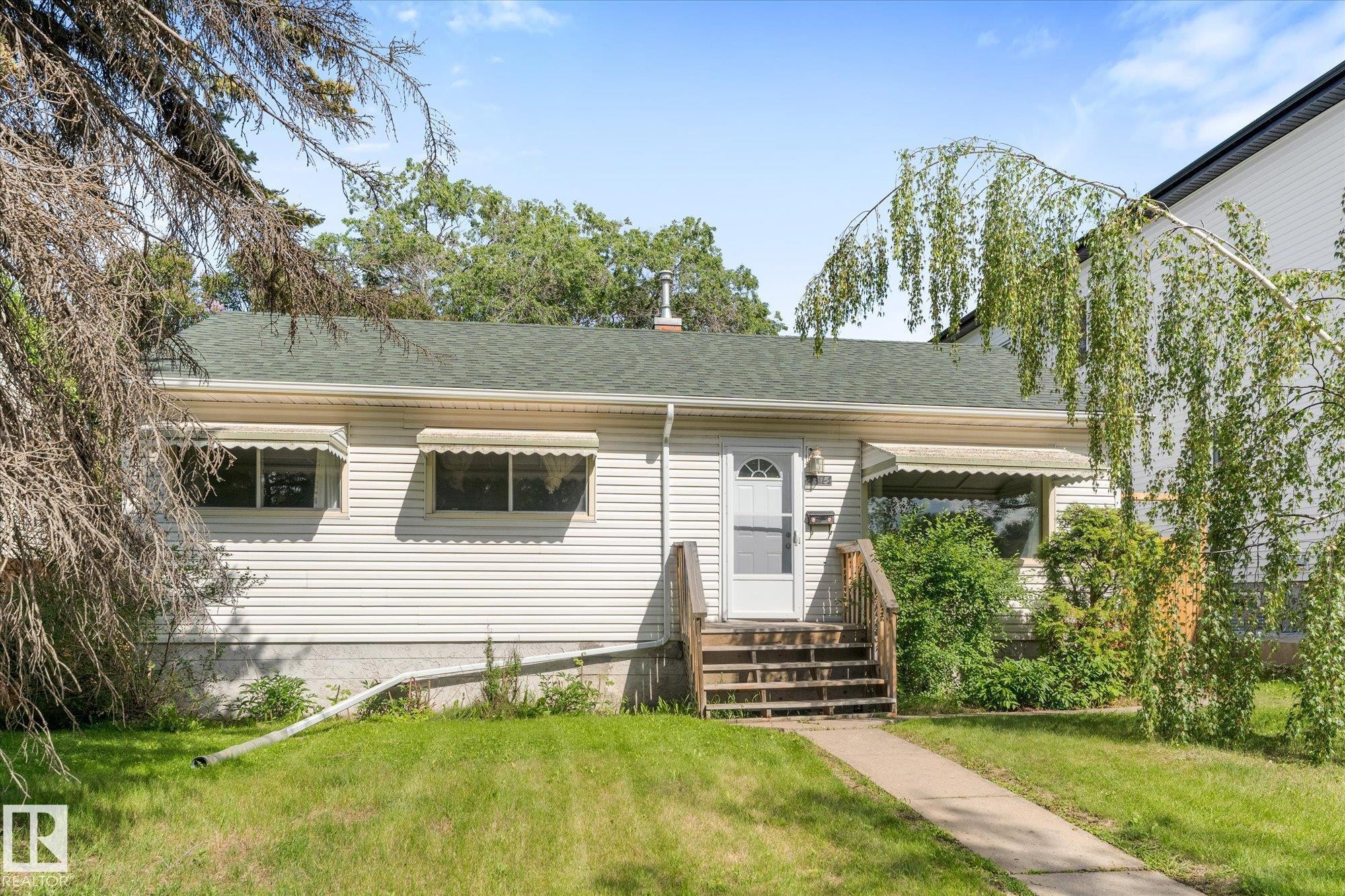 Siding exterior with a green shingle roof, wood porch steps, and a concrete walkway - 9315 86 Street Nw, Edmonton, AB