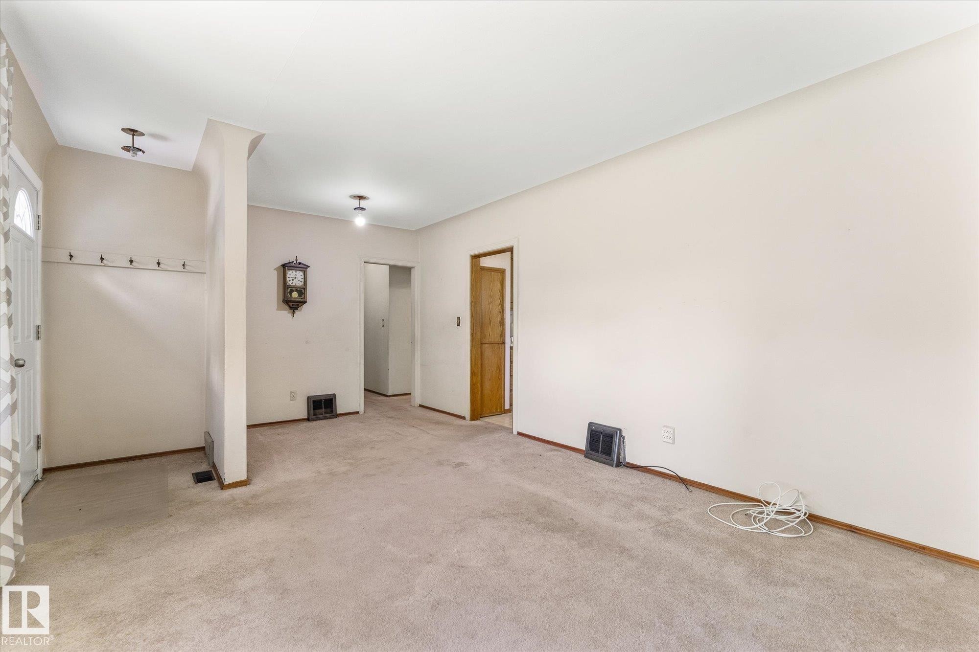 Carpeted flooring, neutral wall tones, white trim, and a white entry door with frosted glass - 9315 86 Street Nw, Edmonton, AB