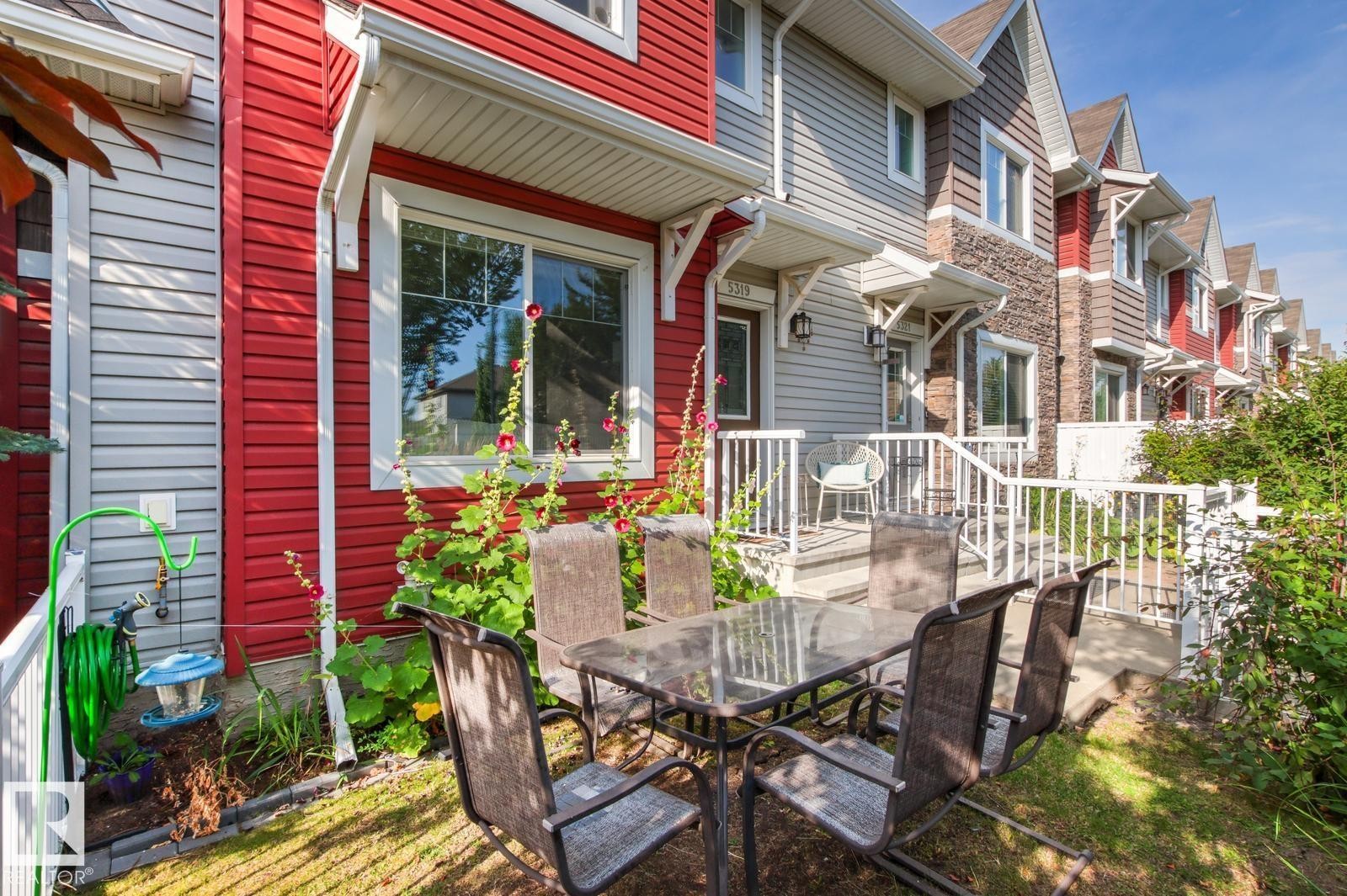 Red vertical siding exterior with white trim and a white eavestrough system - 5319 3 Avenue Sw, Edmonton, AB