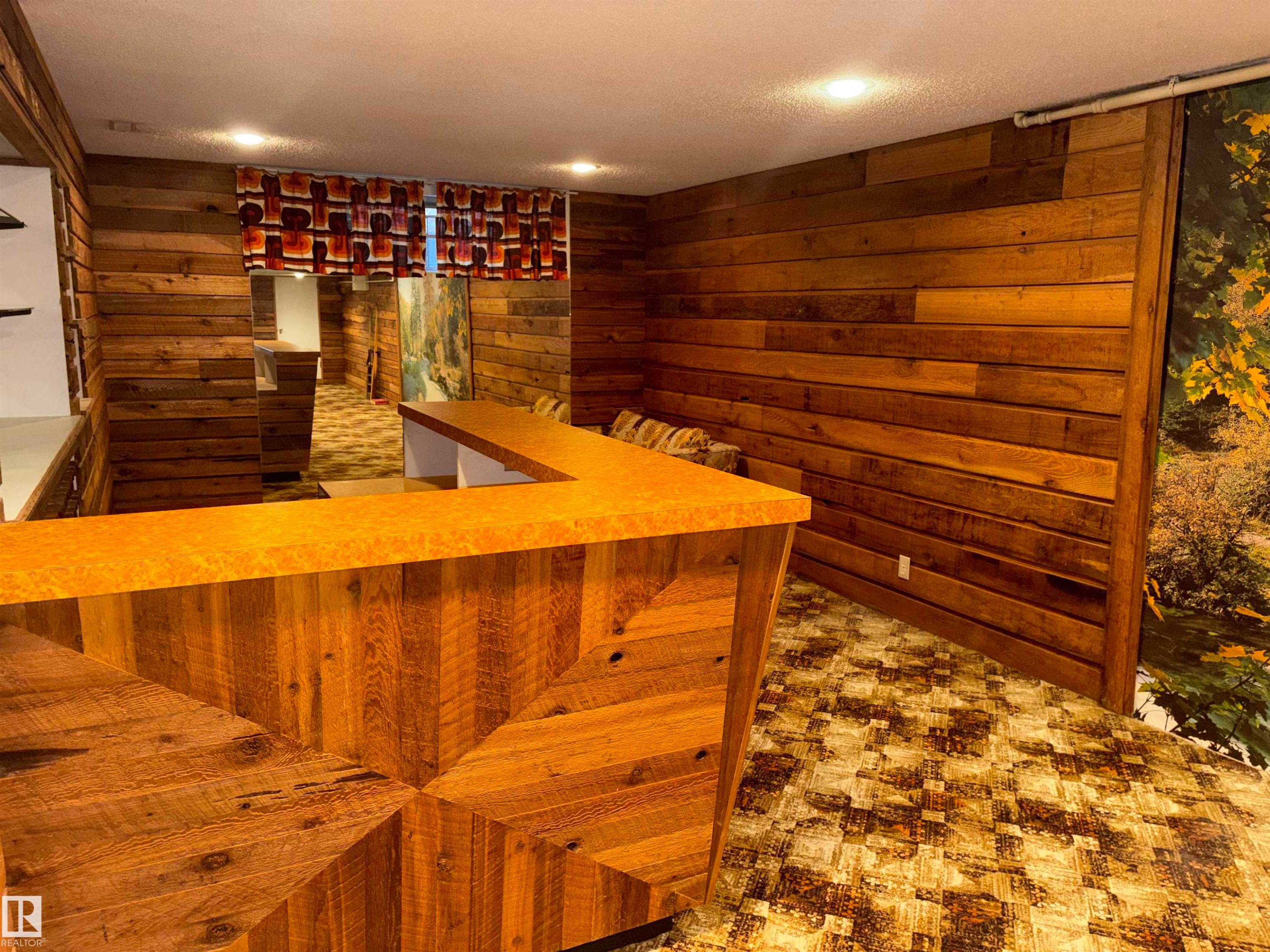 Wood-paneled room featuring a built-in bar with a patterned wood-finish front and a solid surface countertop - 4027 74 Street Nw, Edmonton, AB