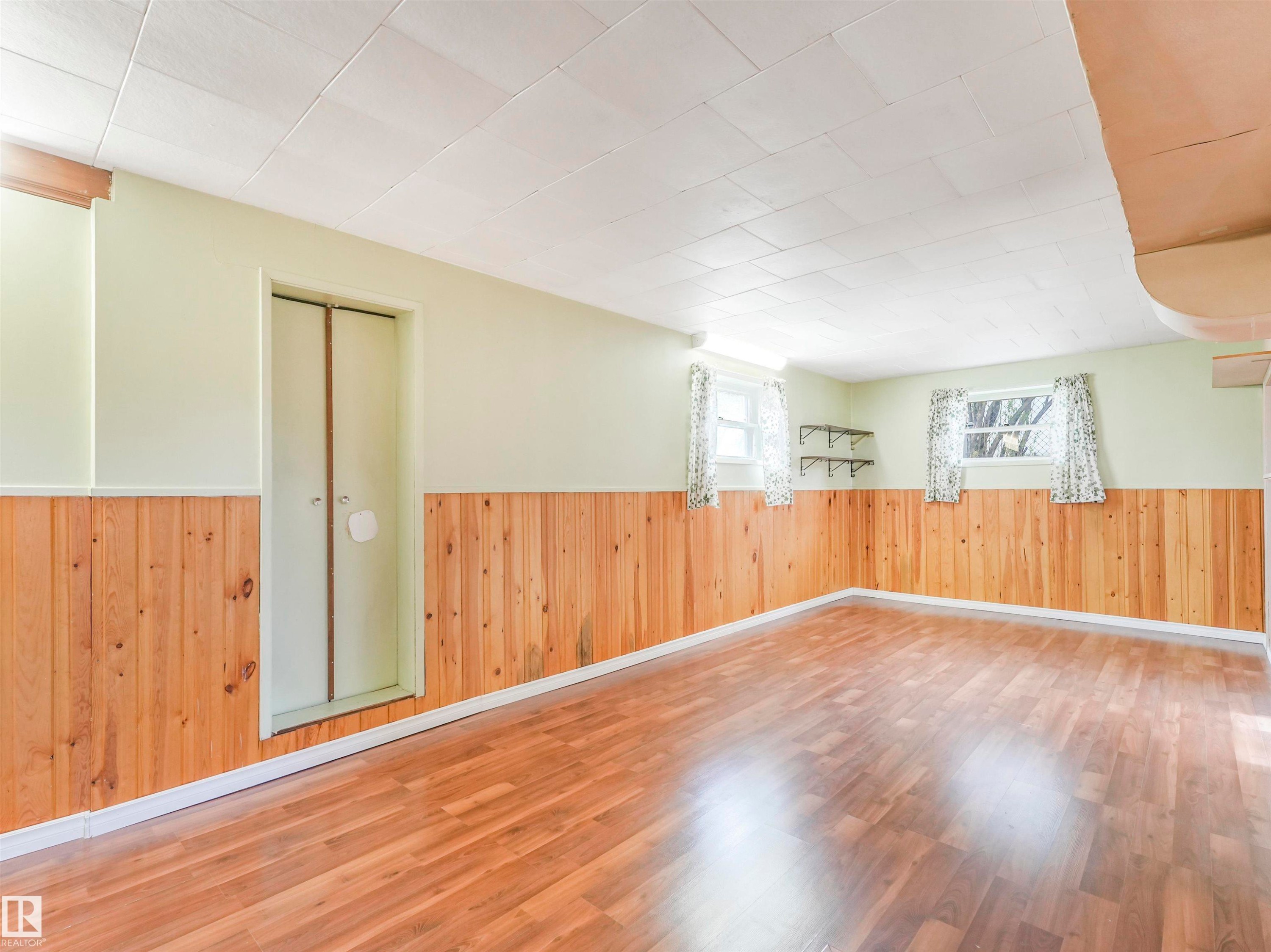 Wood-finish flooring, wood paneling, light-toned walls, and recessed windows - 12614 69 Street Nw, Edmonton, AB