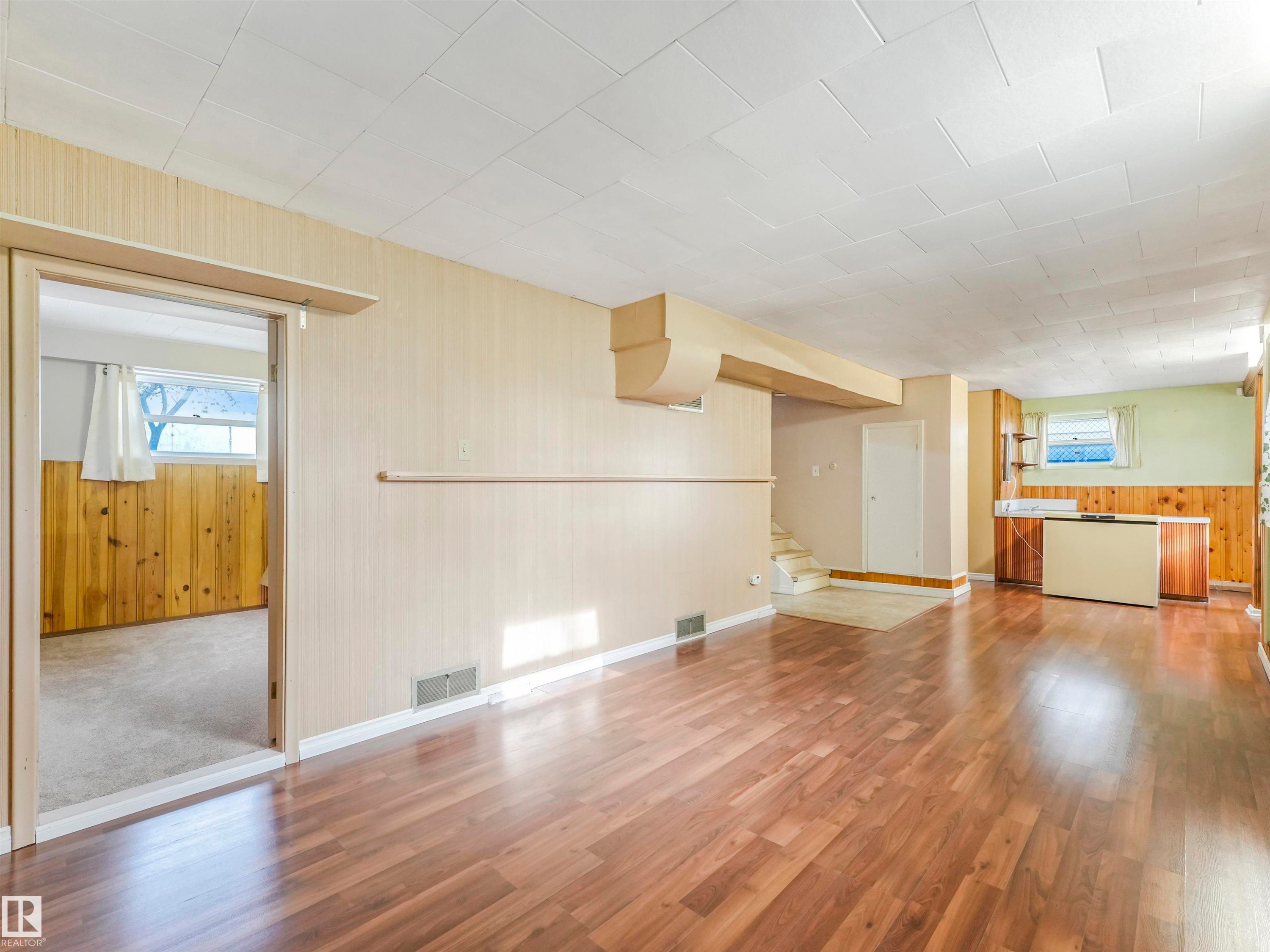 Wood-finish flooring throughout, with a recessed ceiling and exposed wood paneling - 12614 69 Street Nw, Edmonton, AB