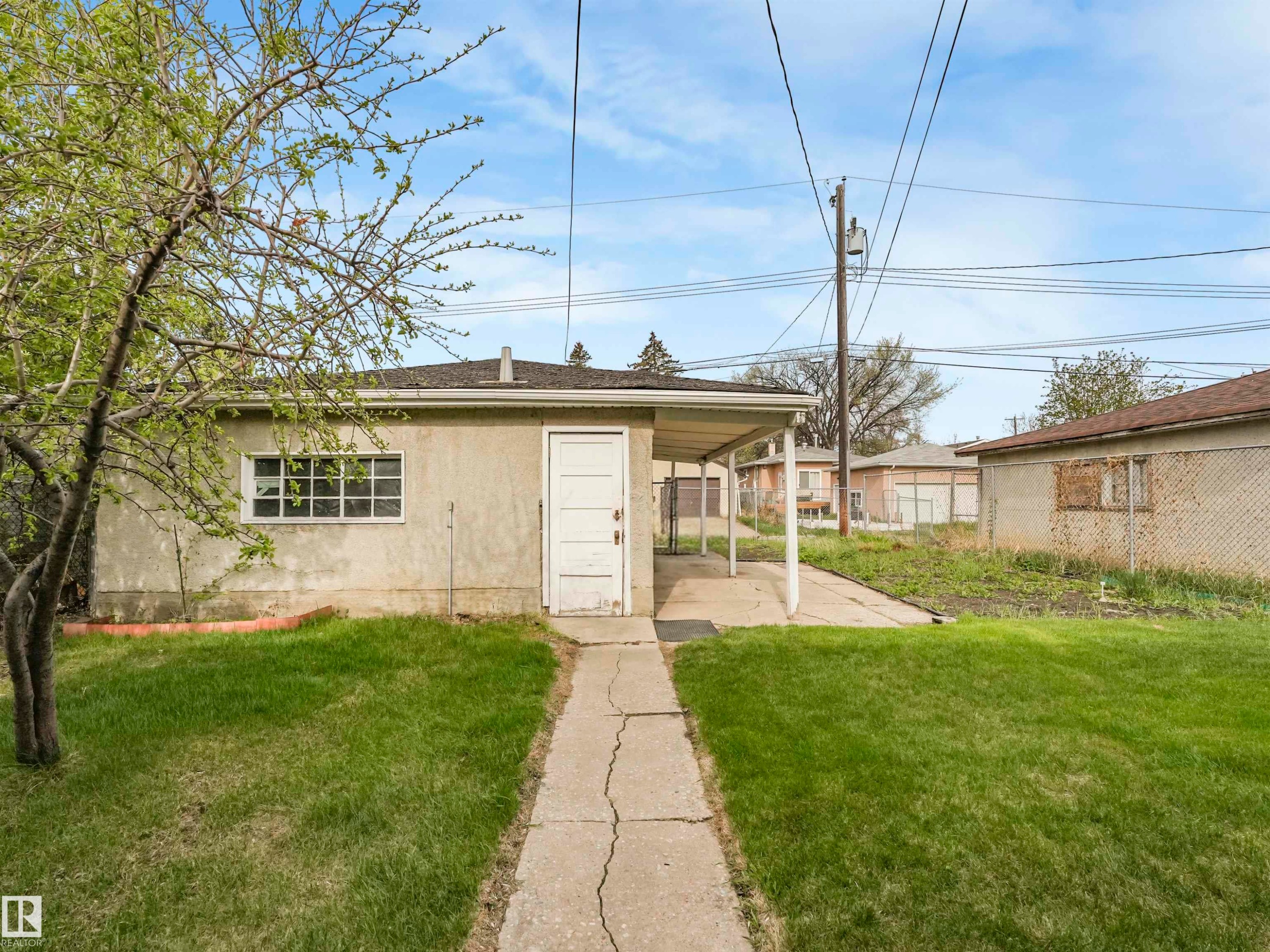 Stucco exterior with a single window and a covered carport area - 12614 69 Street Nw, Edmonton, AB