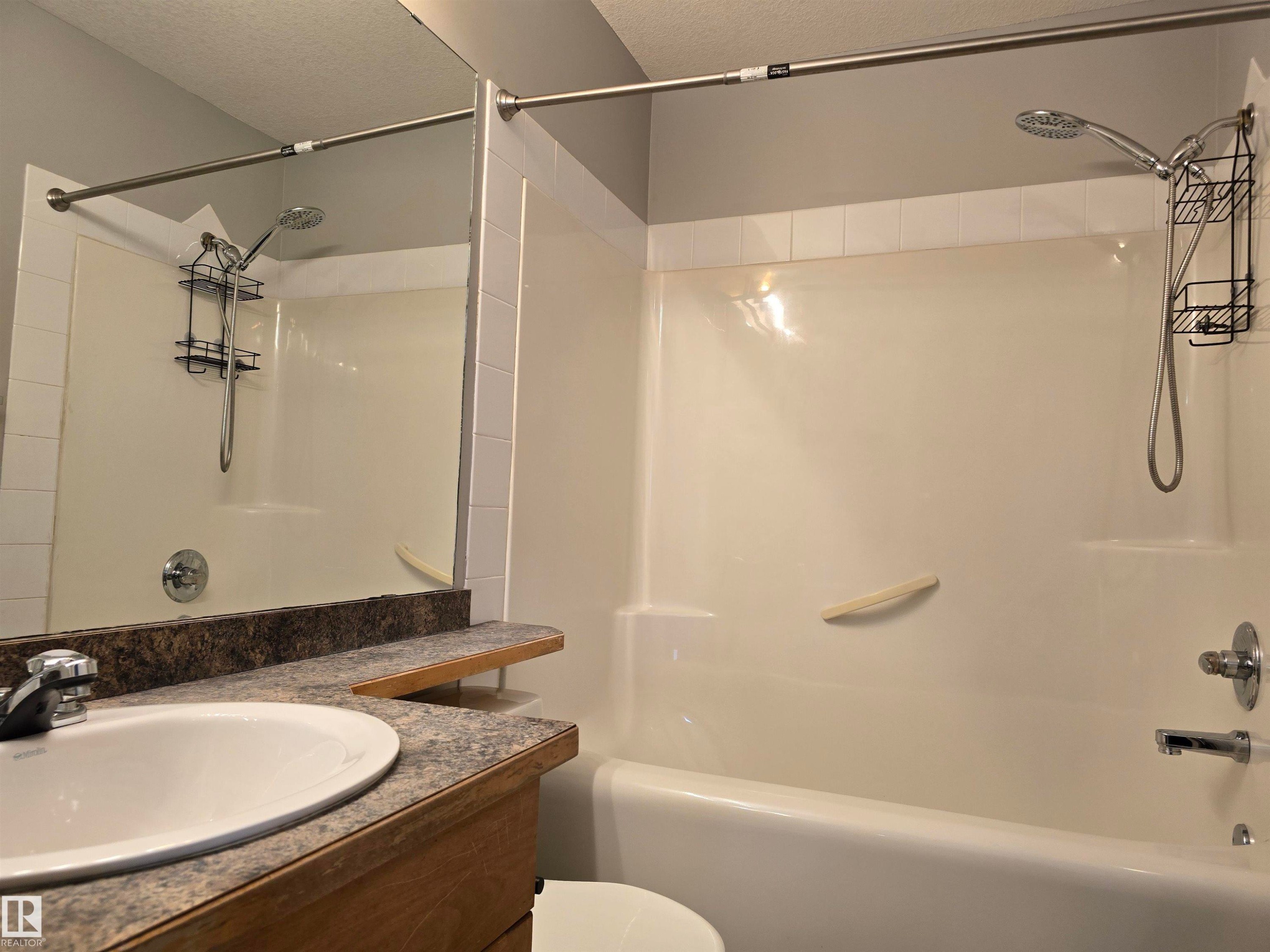 Bathroom featuring a built-in tub and shower - #105 155 Edwards Dr Sw, Edmonton, AB - Indoor Photo Showing Bathroom