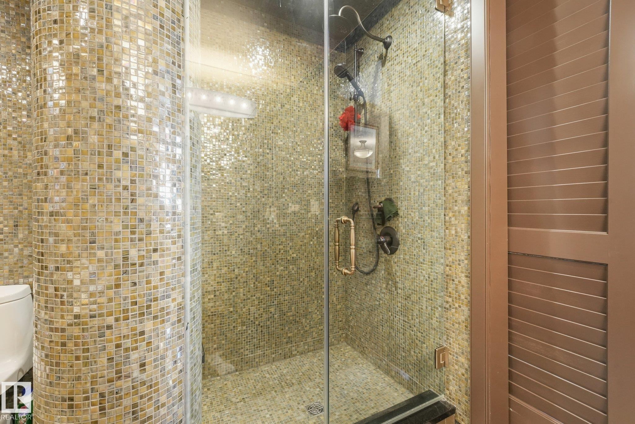 Glass-enclosed shower with full mosaic tile surround, built-in bench, and dual shower heads - 12827 150 Avenue Nw, Edmonton, AB